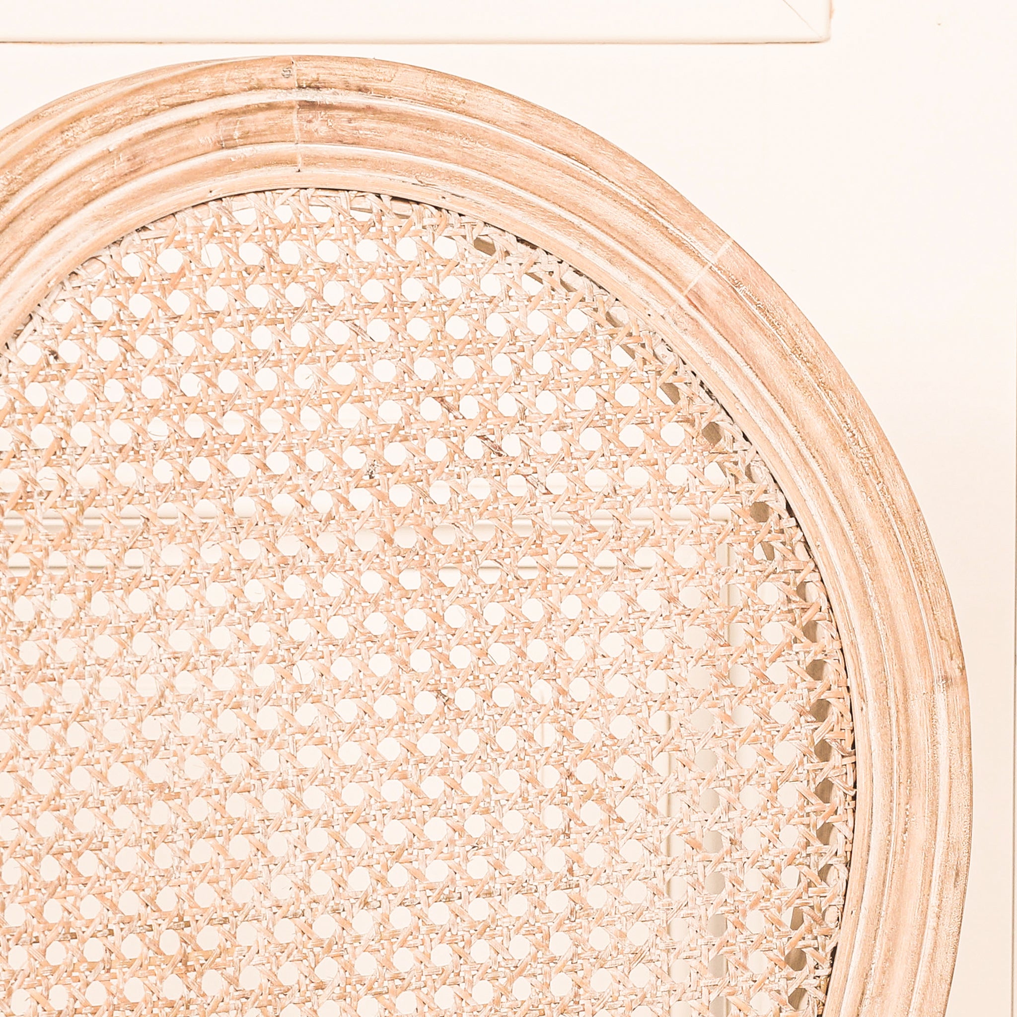 Detailed close-up of the Camille French Louis Linen Upholstered Dining Chair with Light Washed Wood Frame showcasing the oval woven rattan backrest, light washed wood surround and handcrafted natural cane weave.