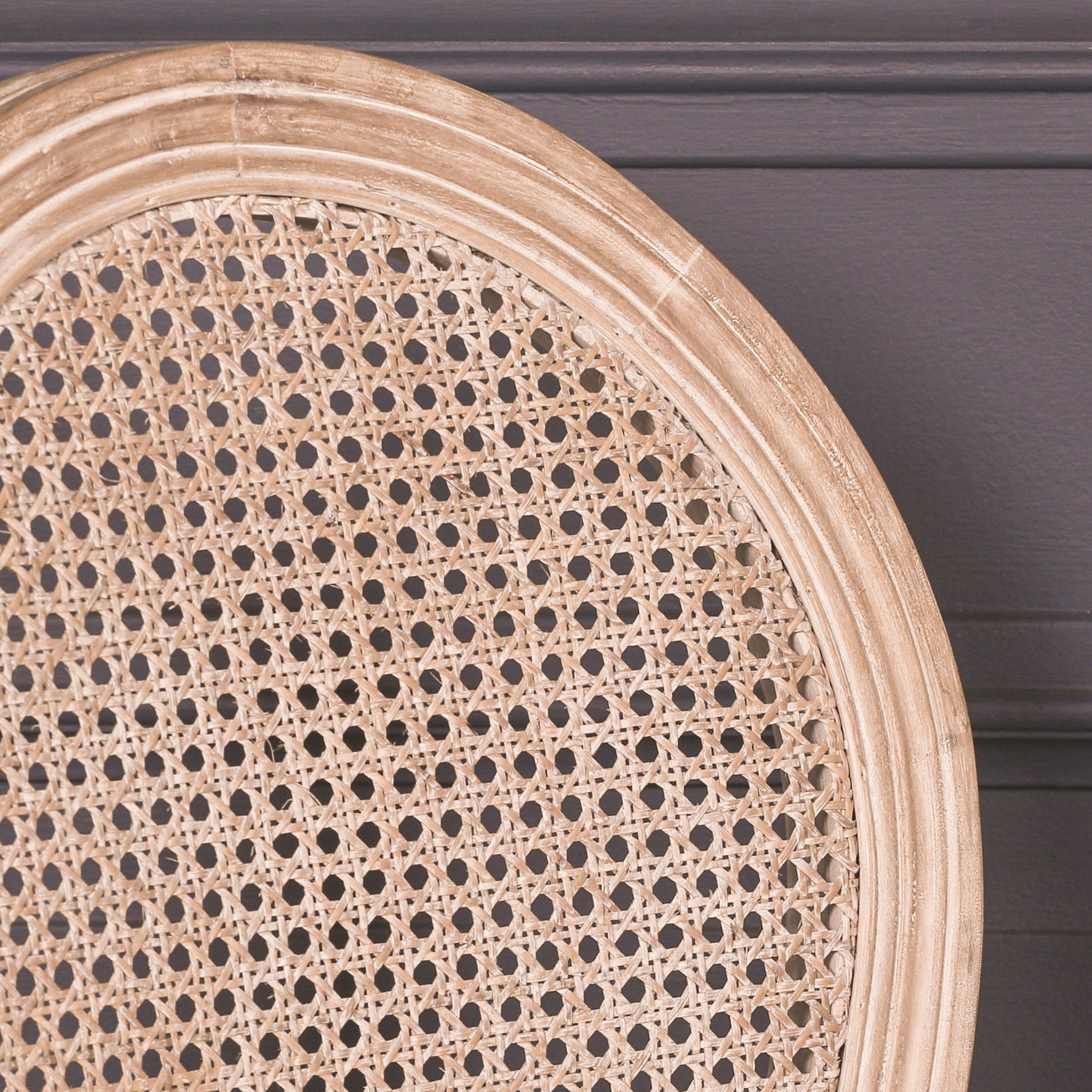 Close-up of the Camille French Louis Linen Upholstered Dining Chair with Light Washed Wood Frame highlighting the handwoven cane backrest, light washed wood frame and traditional French Louis craftsmanship.