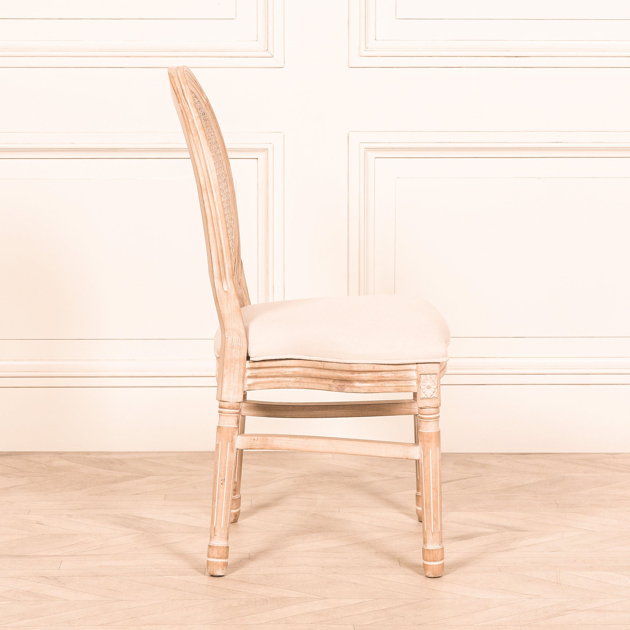 Side profile of the Camille French Louis Linen Upholstered Dining Chair with Light Washed Wood Frame highlighting the upholstered linen seat, curved Louis-style frame, hand-carved detailing and solid wood construction.