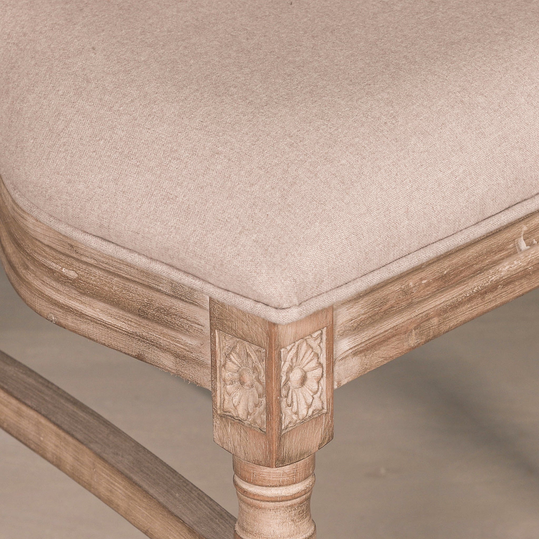 Detailed close-up of the Camille French Louis Rattan Back Dining Chair showing the linen upholstered seat, hand-carved floral corner block and solid wooden frame.