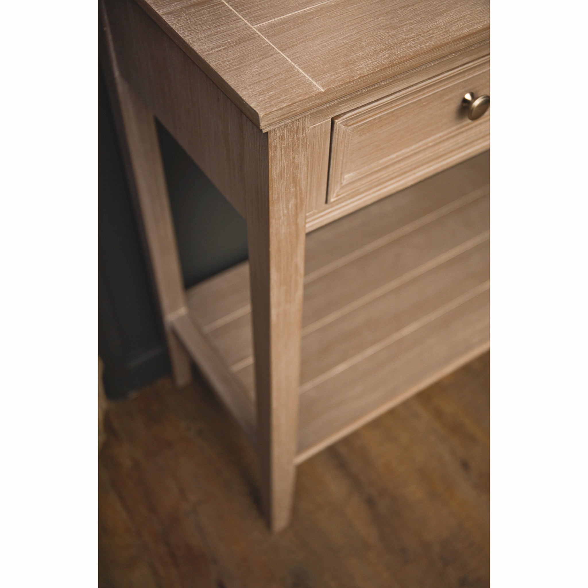 Detail of the Camille grey wooden console table highlighting the slim wooden legs, lower display shelf, framed drawer front and painted wood finish, ideal for elegant hallway, living room and entrance furniture.