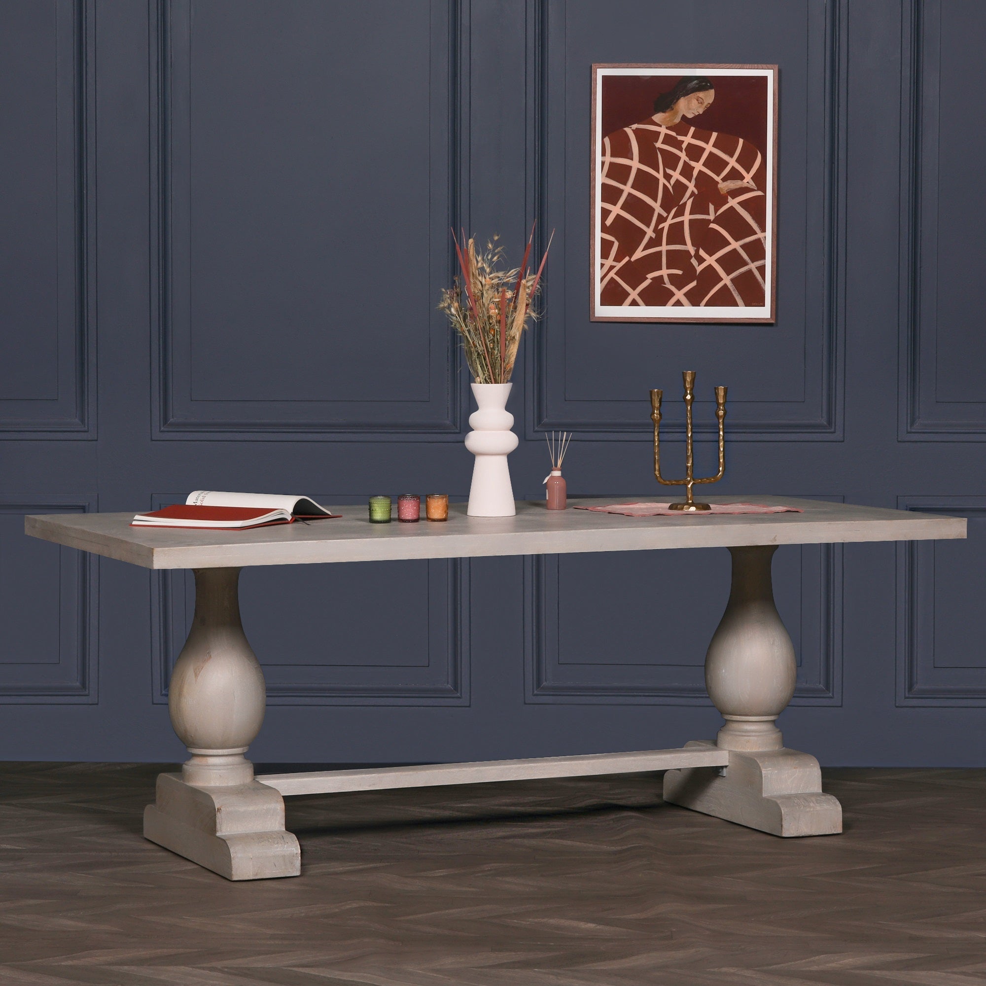 Styled three-quarter view of the Camille Large Rectangular Dining Table 210cm for 8–10 in Bleached Mango Wood with decorative accessories, showcasing the spacious solid wood tabletop and elegant pedestal trestle base.
