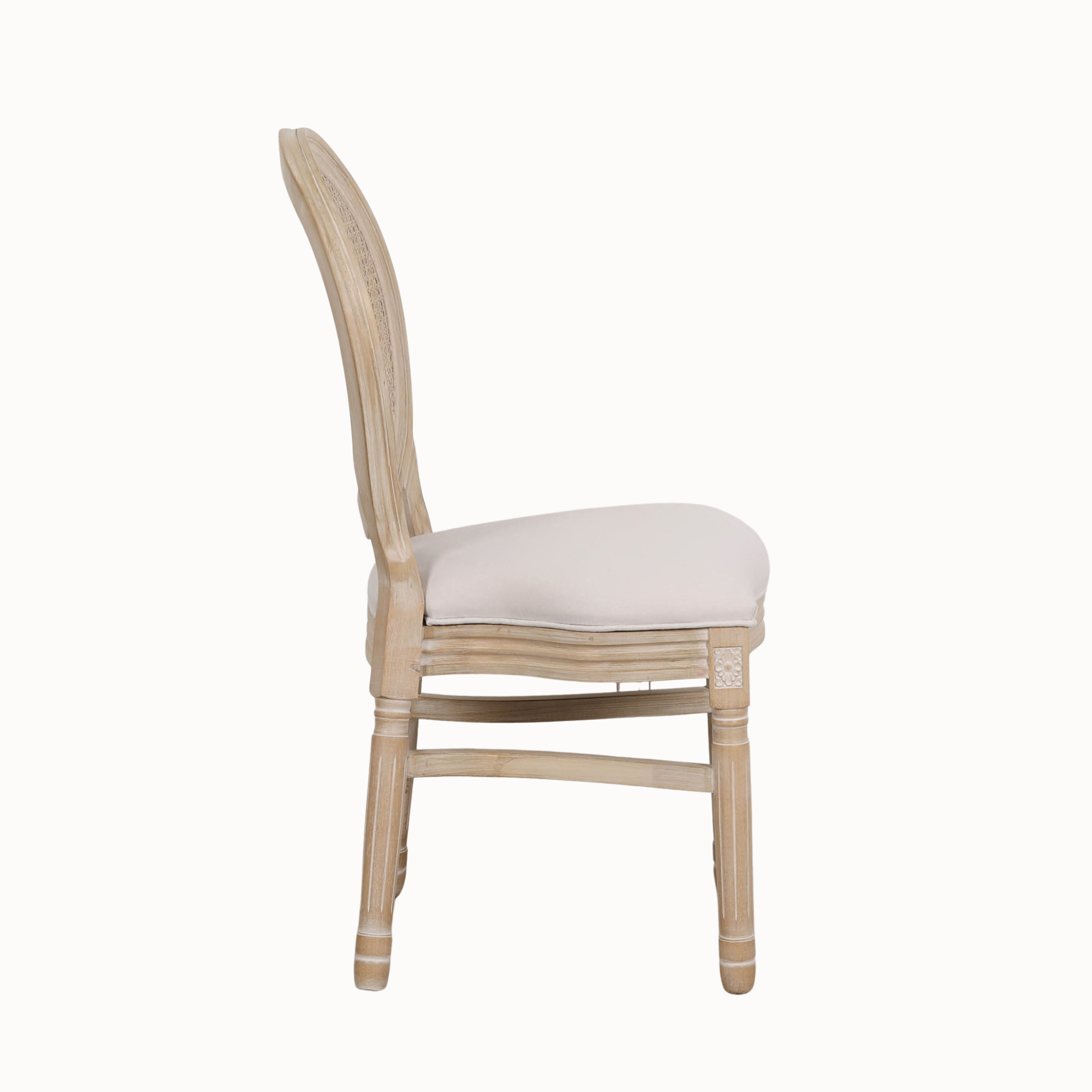 Side view of Camille linen upholstered dining chair with cane back and light washed wood frame on a white background.