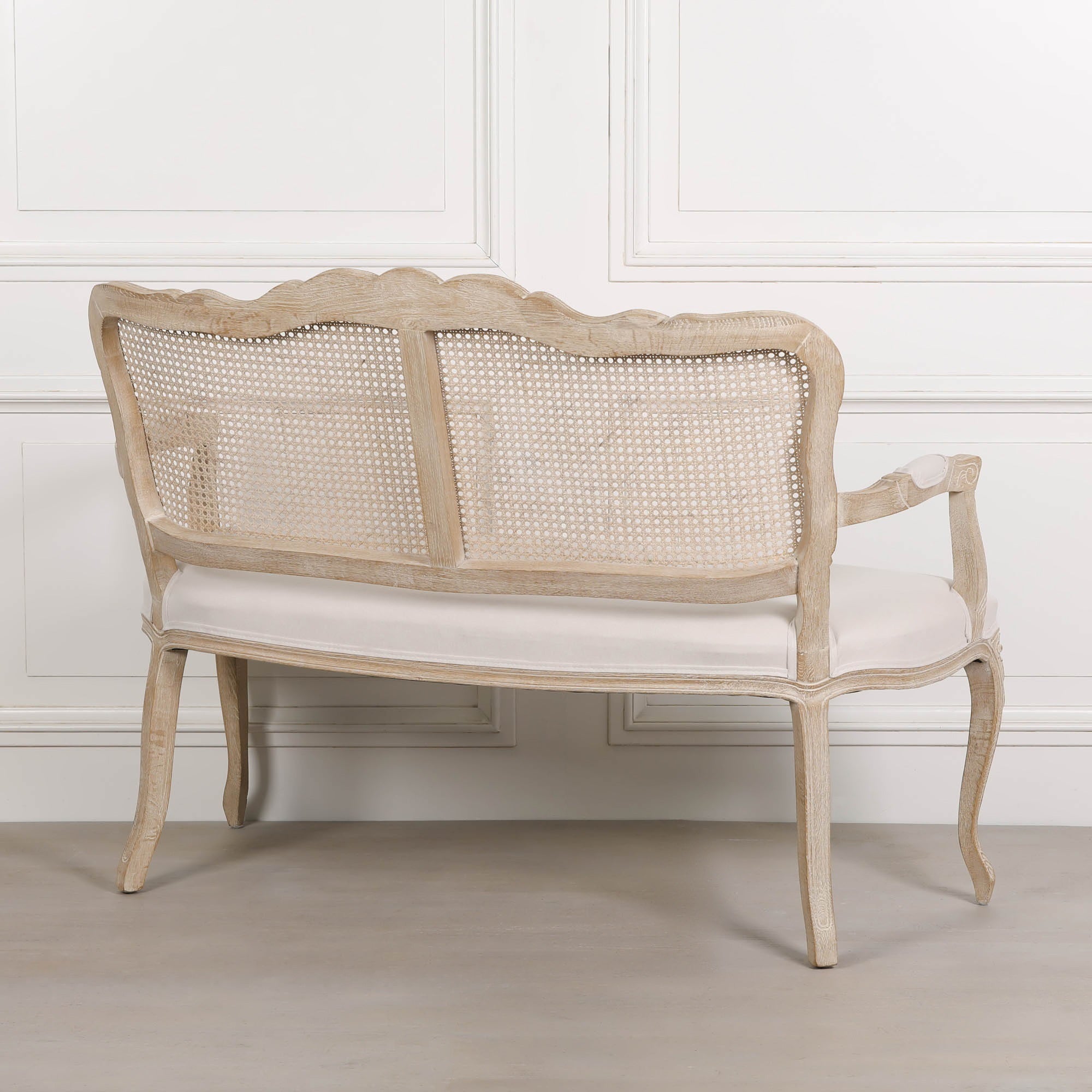 Rear angled view of Camille French Louis 2 seater settee showing natural cane back, birch wood frame and linen seat.