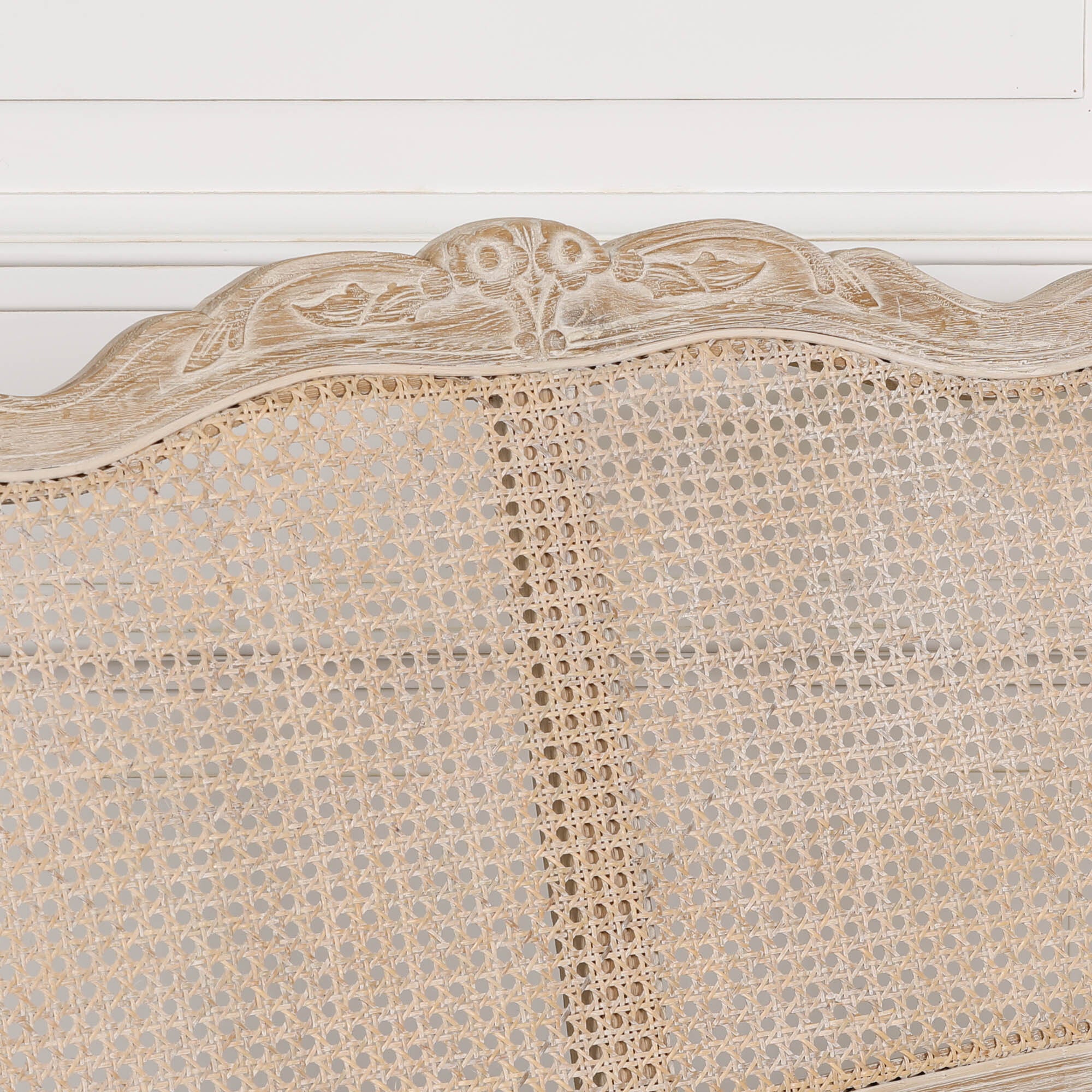 Close-up of Camille Louis settee showing natural cane back and ornate carved birch wood crest detail.