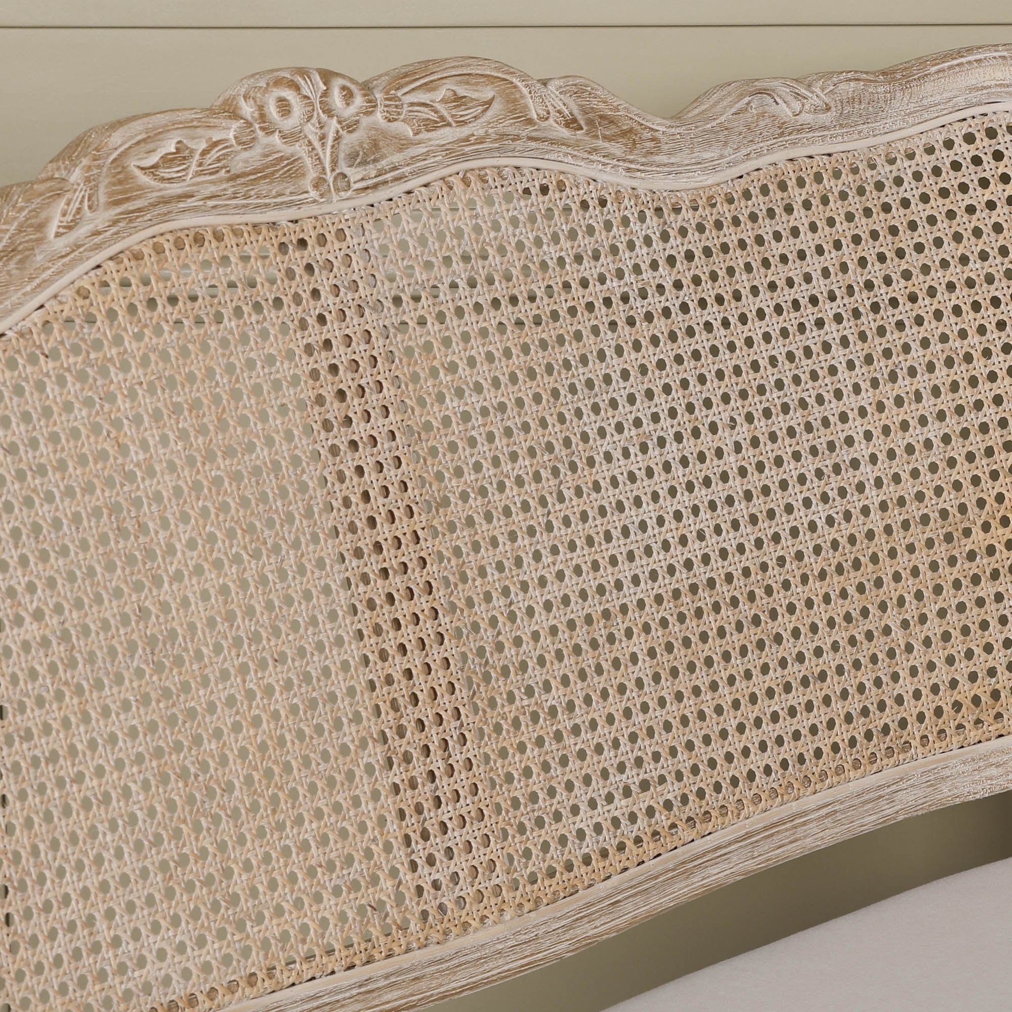 Close-up of Camille Louis settee natural cane back and carved birch wood frame with distressed finish.