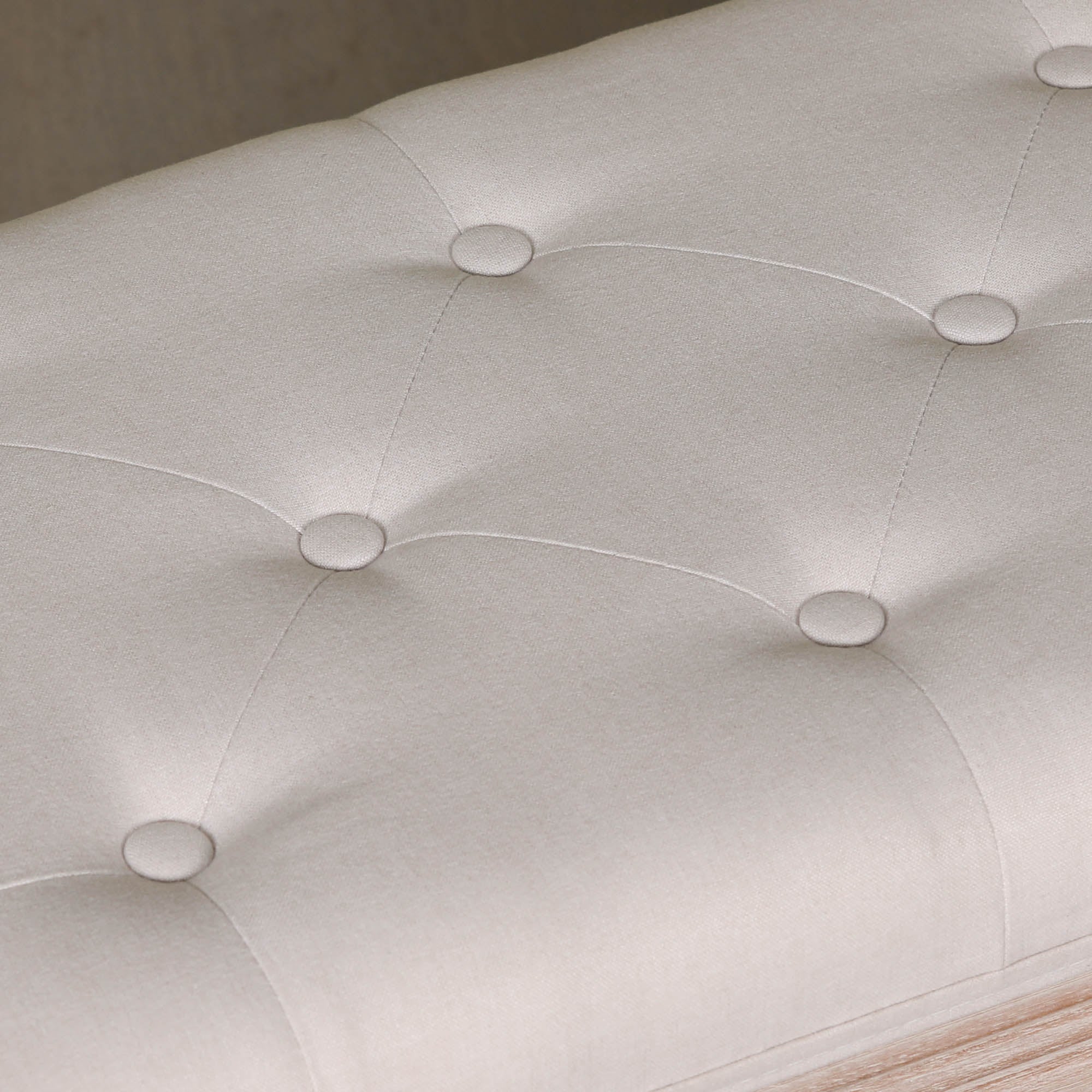 Detailed close-up of the Camille Louis Upholstered Bench featuring the soft beige button tufted linen upholstery with deep tufting and tailored stitching, highlighting the luxurious finish and timeless French style.