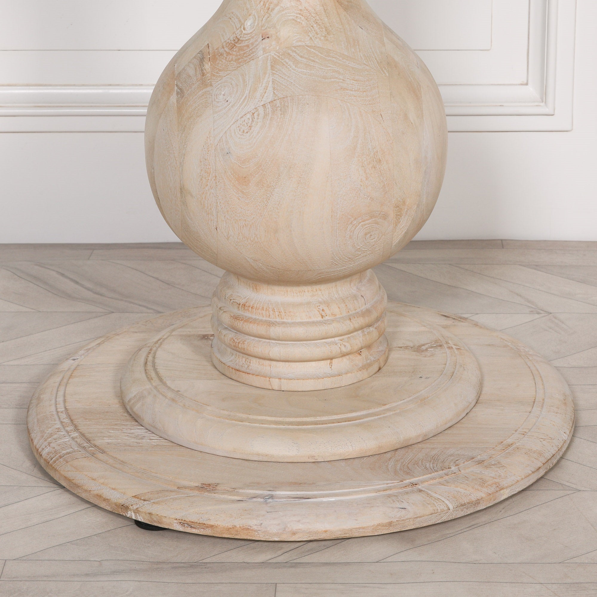 Close-up of the sculptural pedestal base on the Camille Round Pedestal Dining Table 152cm for 6 in Bleached Mango Wood, highlighting the turned timber craftsmanship, natural wood grain and solid handcrafted construction.