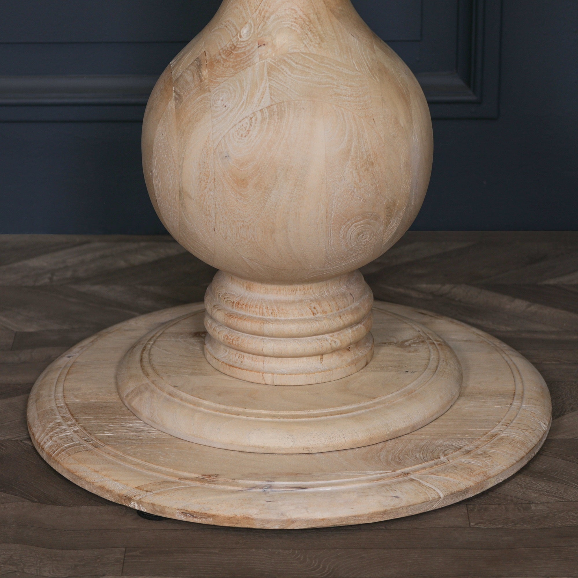 Close-up of the turned pedestal base on the Camille Round Pedestal Dining Table in Bleached Mango Wood, showcasing the natural timber grain, handcrafted detailing, circular plinth base and premium solid mango wood craftsmanship.