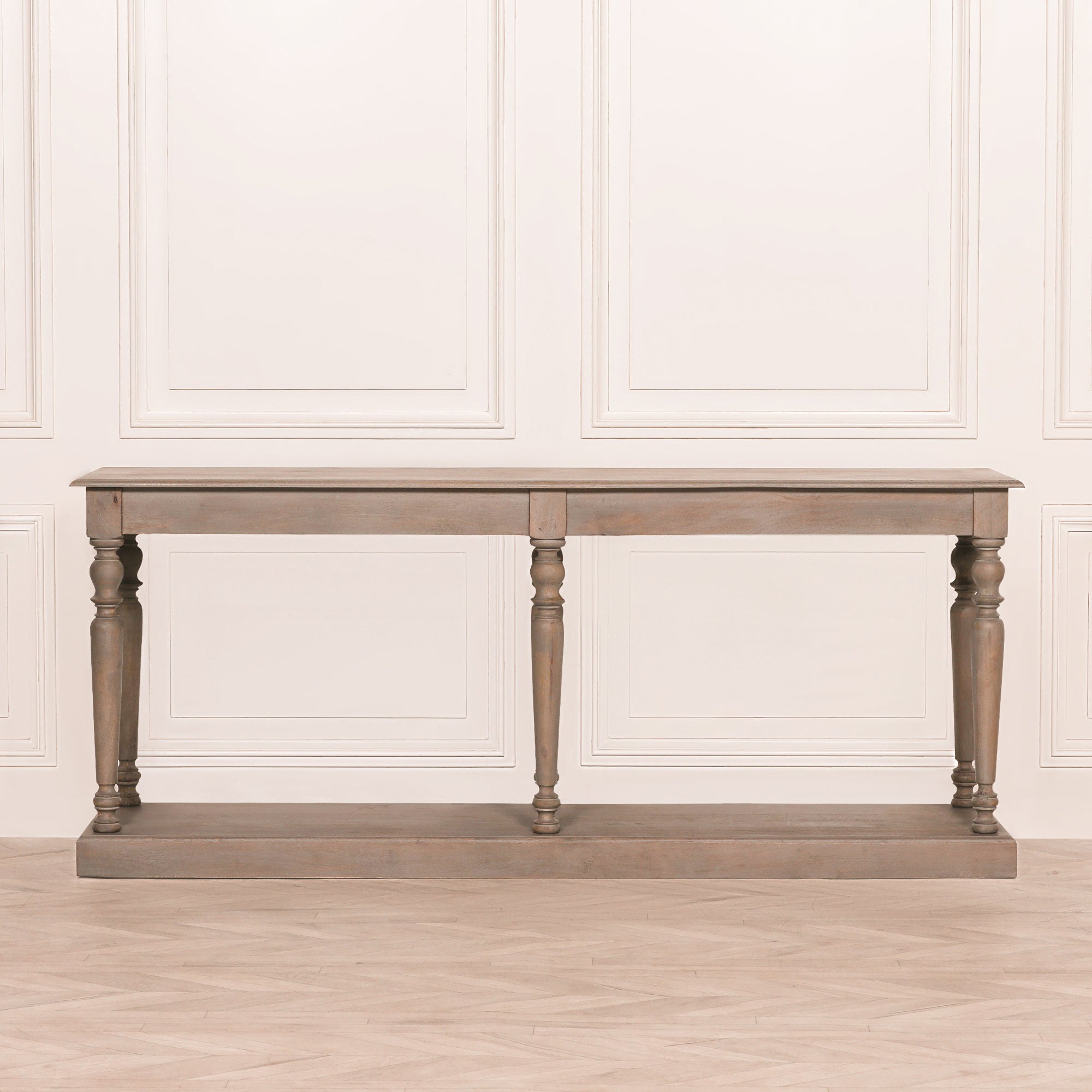 Front view of the Camille rustic wooden console table with six turned column legs, spacious tabletop and full-width lower shelf, finished in weathered grey wood for timeless farmhouse and French country interiors.