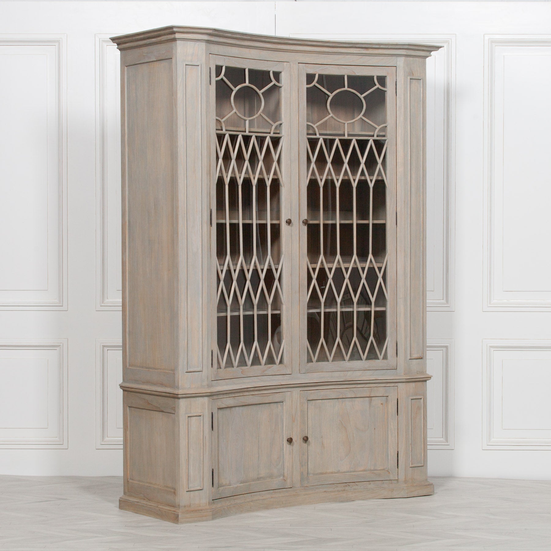 Camille white cedar concave display cabinet with decorative glass doors against a white panelled wall.