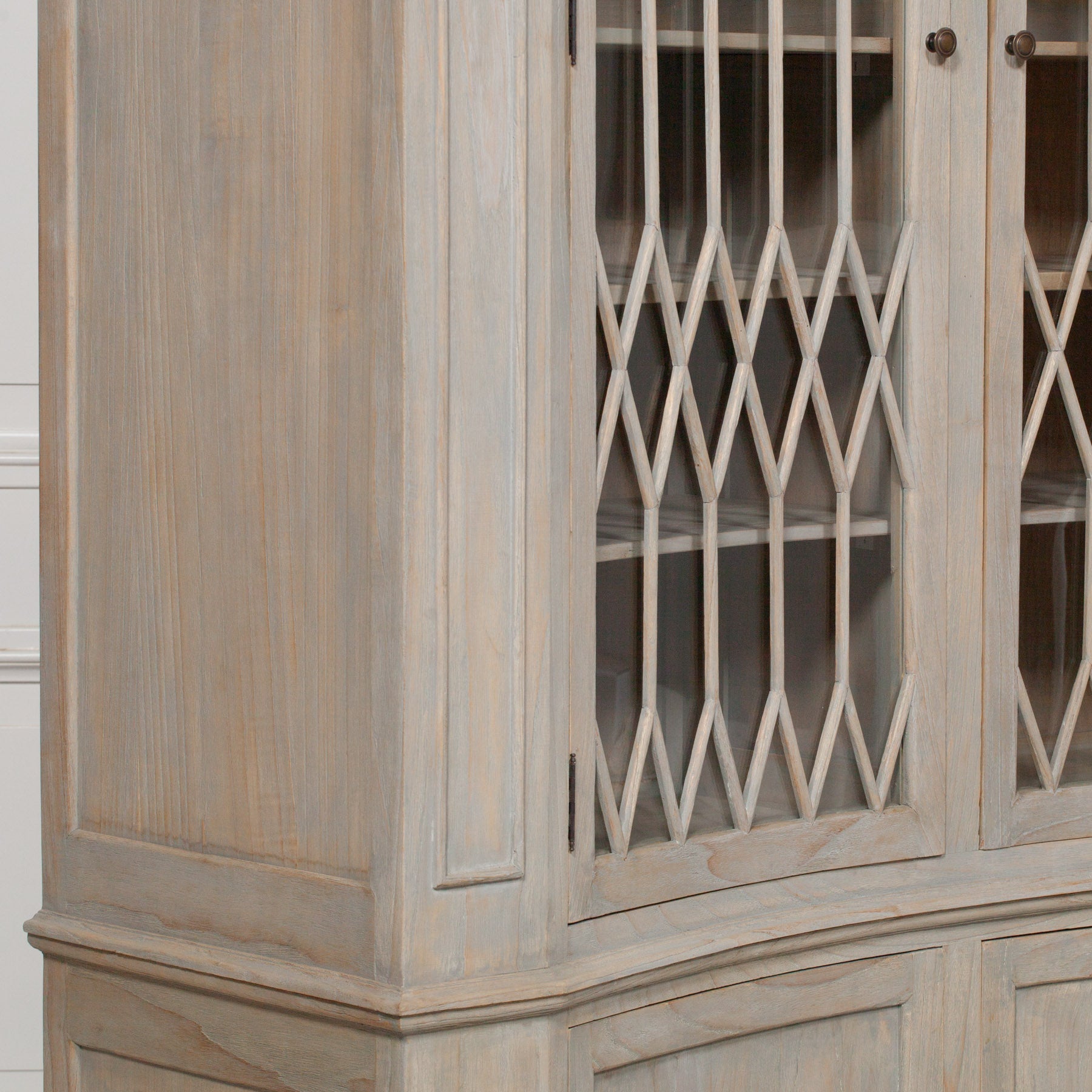 Close-up of Camille white cedar display cabinet decorative glass lattice doors against a white panelled wall.