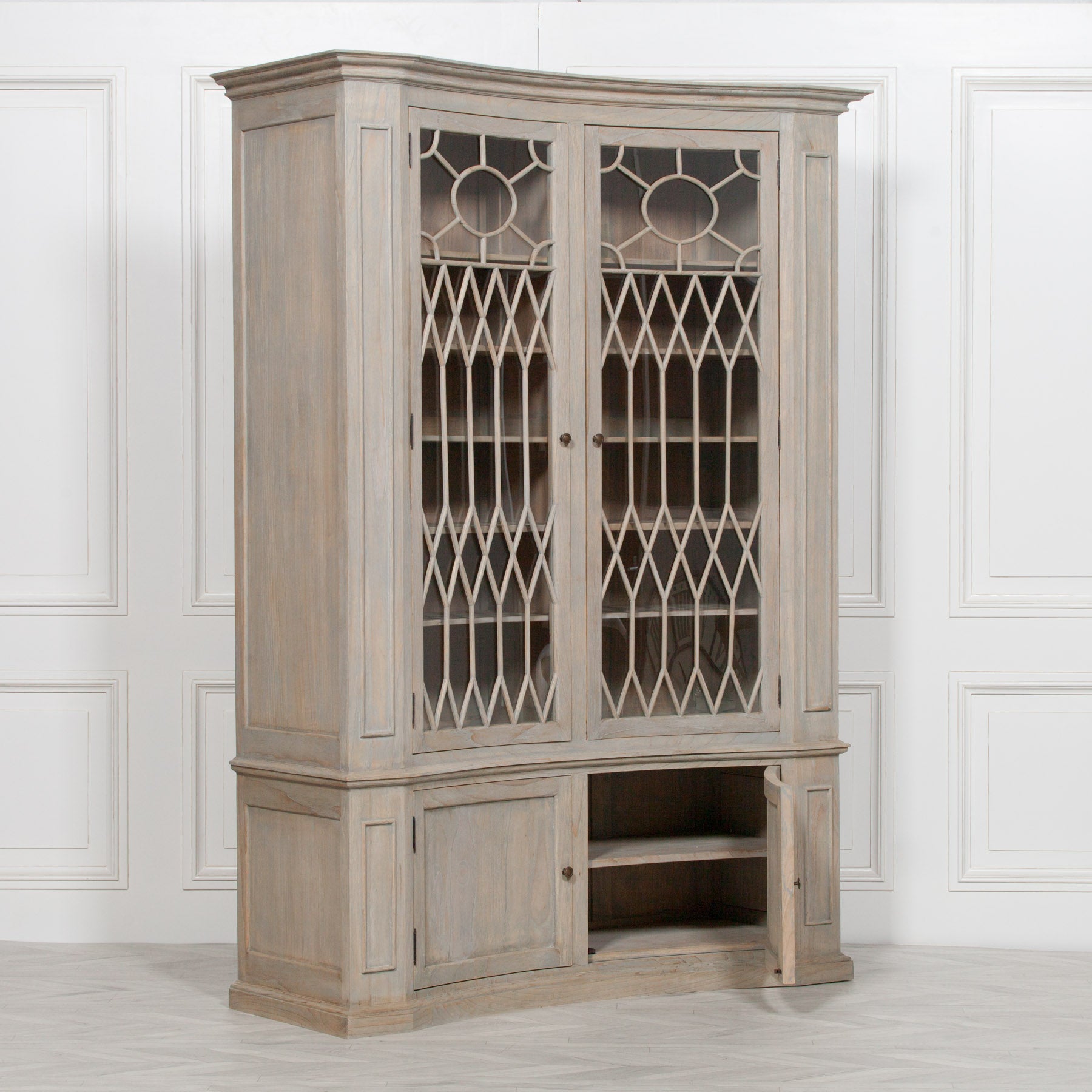 Camille white cedar display cabinet with one lower storage door open against a white panelled wall.