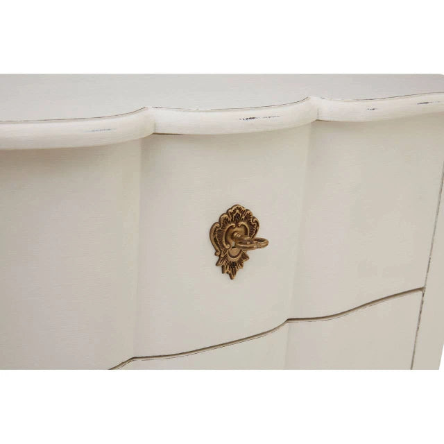 Close-up of Camille chest of drawers showing scalloped drawer fronts and ornate antique gold handle on white.