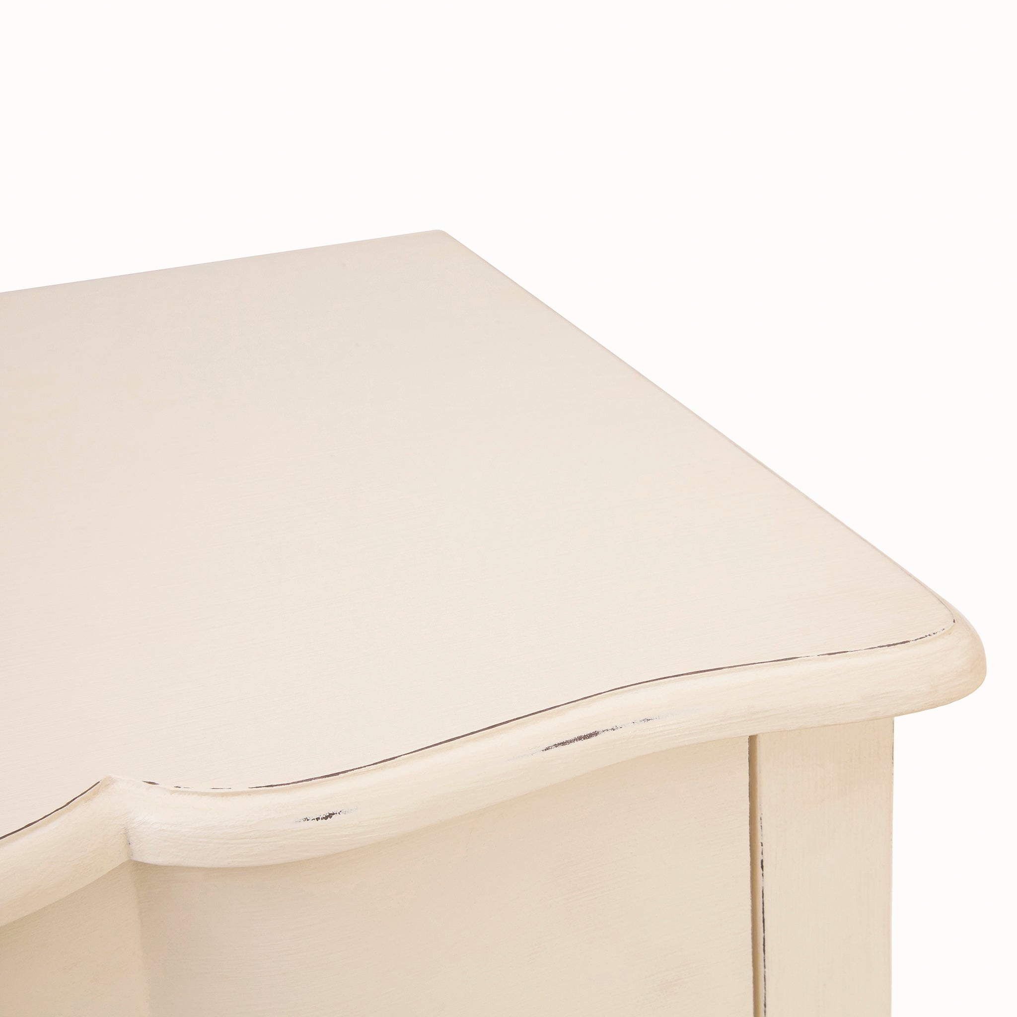 Close-up of the Camille five drawer chest showing its softly shaped top, white painted finish and subtle distressed edge detailing characteristic of its elegant French-inspired design.