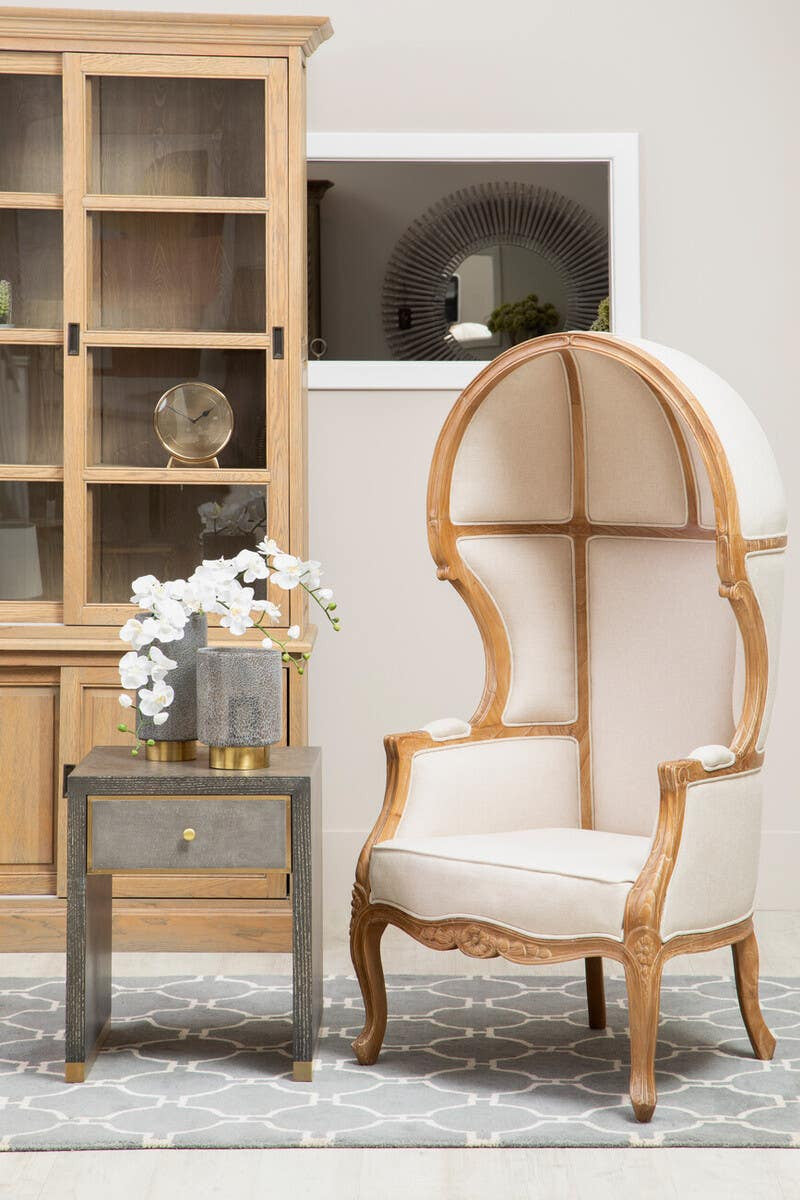 Colette Cream Dome Accent Chair with Canopy Back & Cabriole Legs styled in a luxury living room beside a side table and display cabinet, showcasing its elegant dome canopy back, upholstered cream fabric and carved wooden frame.