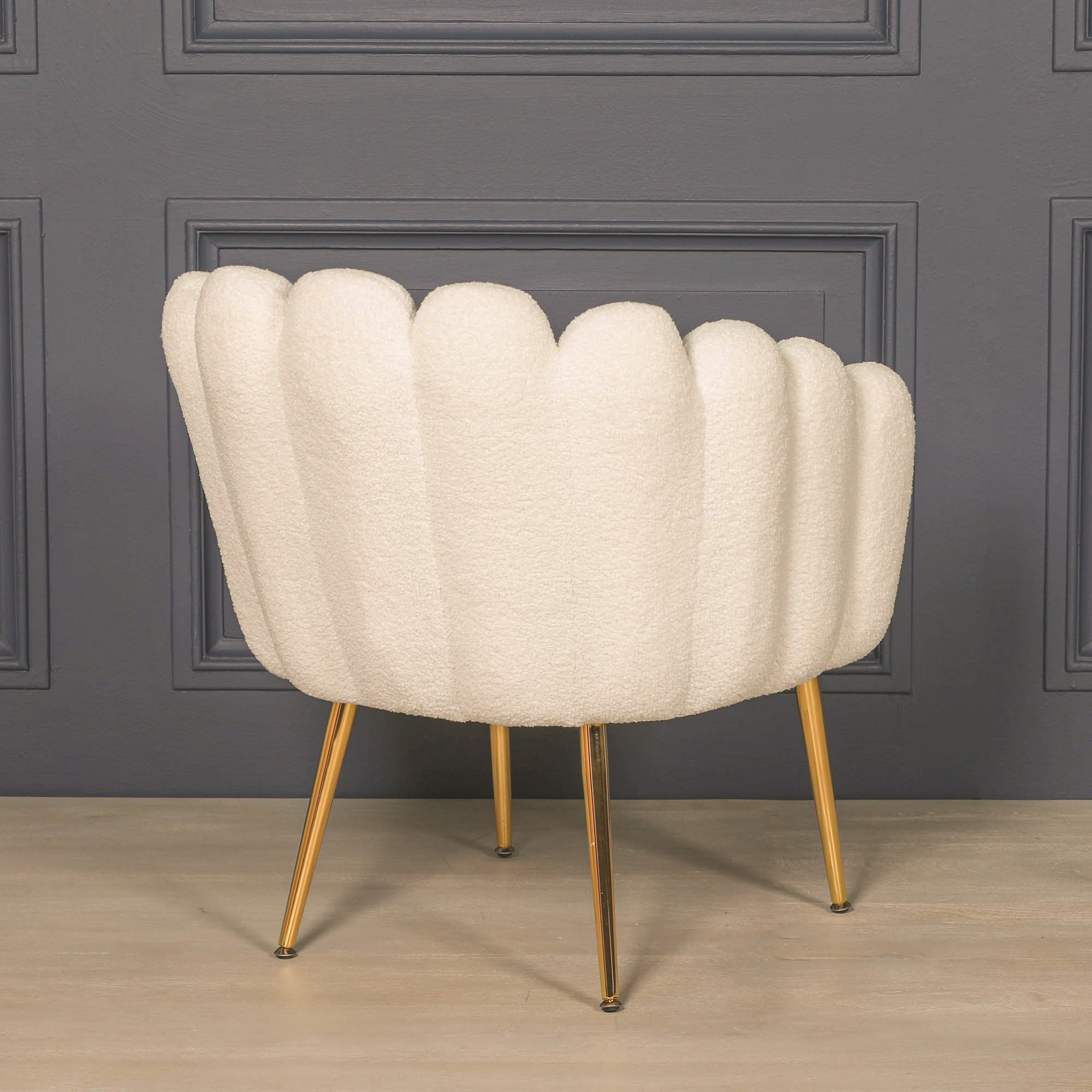 Rear view of the Elara Scalloped White Bouclé Dining Chair with Gold Metal Legs displaying the elegant scalloped shell design, luxurious textured bouclé upholstery, curved wraparound back and slim gold metal legs.