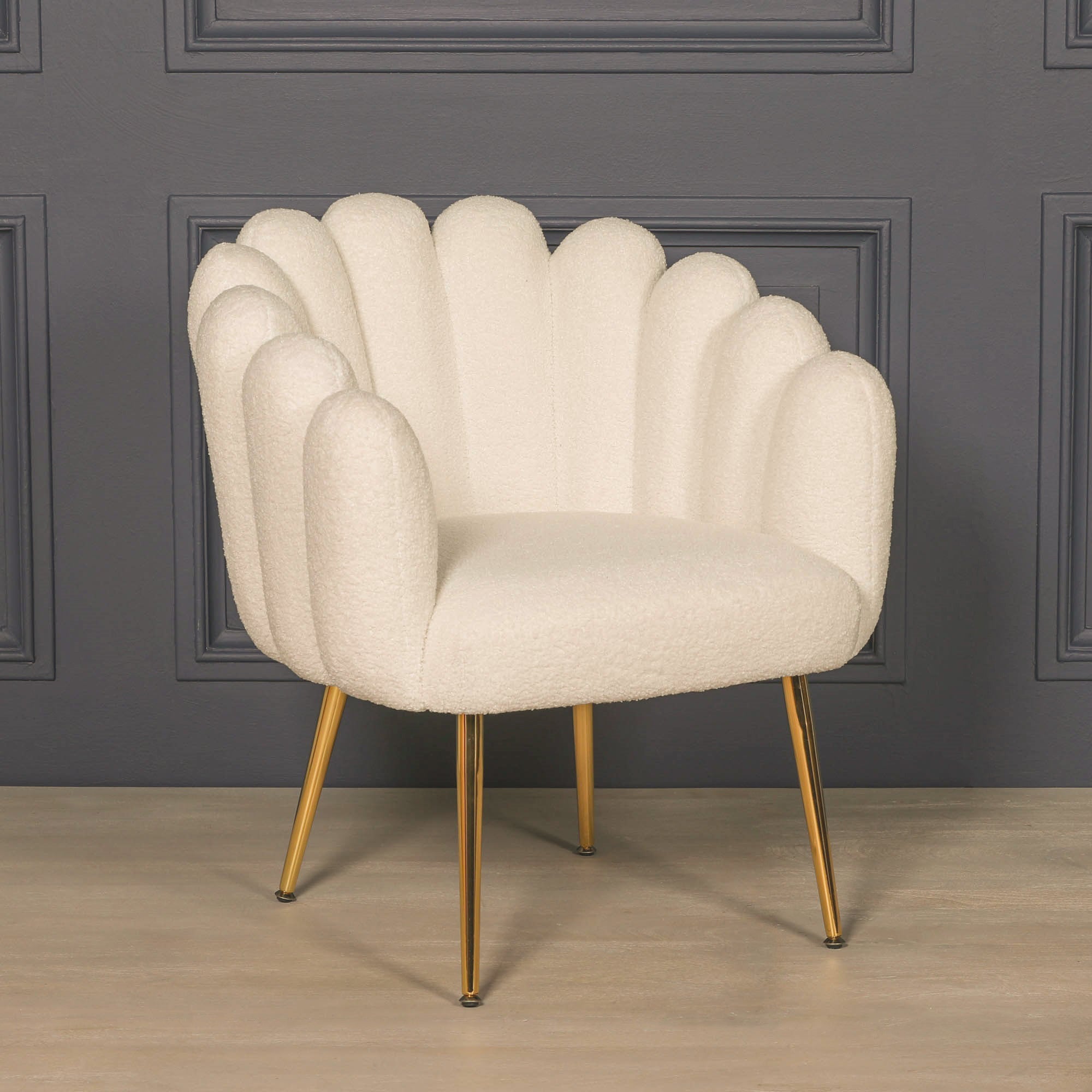 Front three-quarter view of the Elara Scalloped White Bouclé Dining Chair with Gold Metal Legs highlighting the curved scalloped silhouette, soft textured bouclé fabric, supportive wraparound backrest and contemporary gold metal legs.