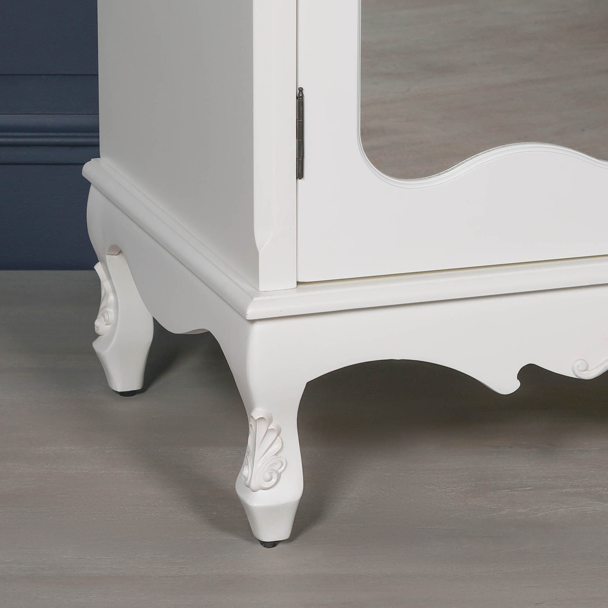 Detailed view of the Élodie White Mirrored Double Door Armoire Wardrobe highlighting the carved cabriole feet, decorative apron, painted white finish and elegant French-style craftsmanship at the base of the wardrobe.