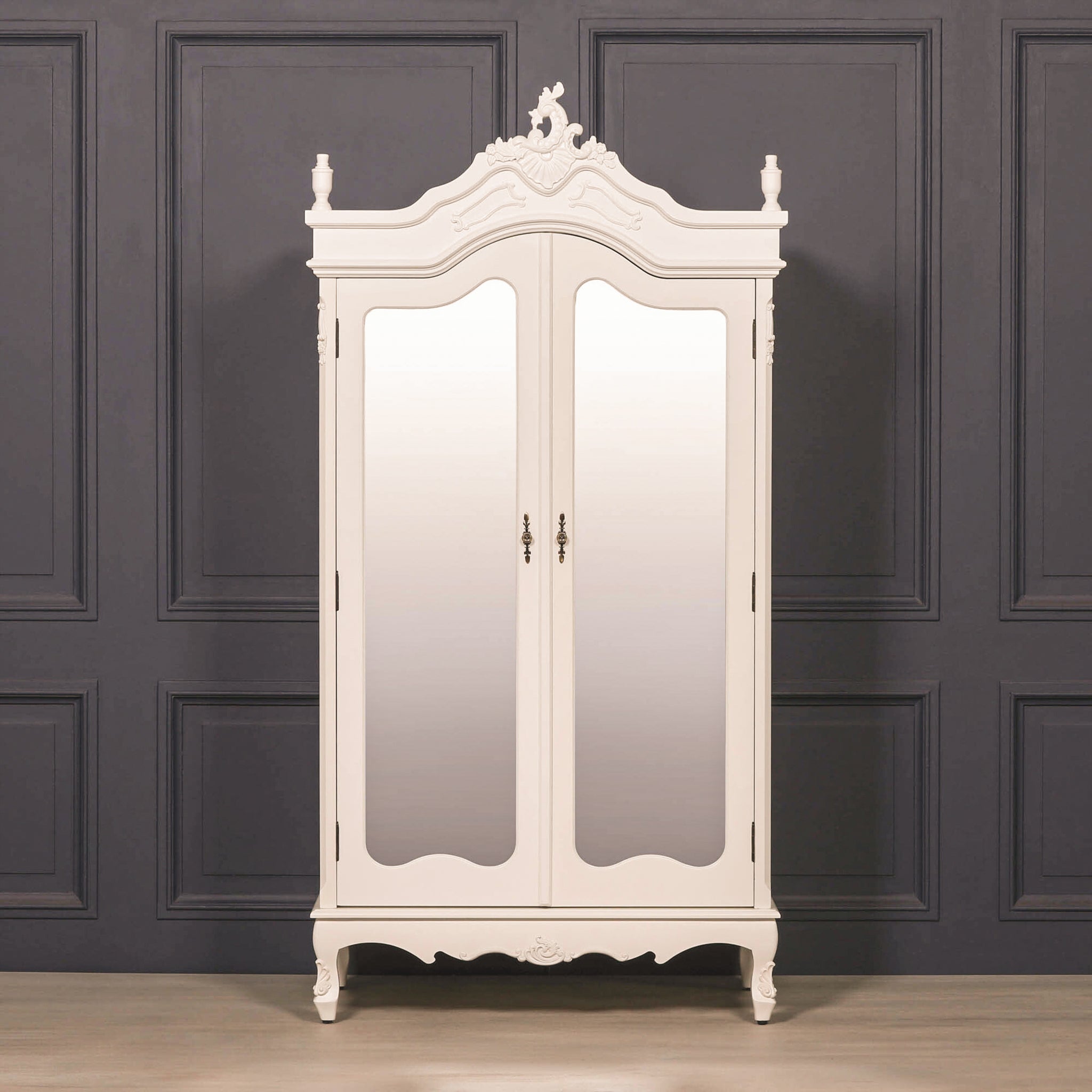 Élodie White Mirrored Double Door Armoire Wardrobe featuring elegant French Rococo styling, full-length mirrored doors, ornate hand-carved crown detailing, decorative cabriole feet and a painted white finish, styled in a luxury bedroom interior.