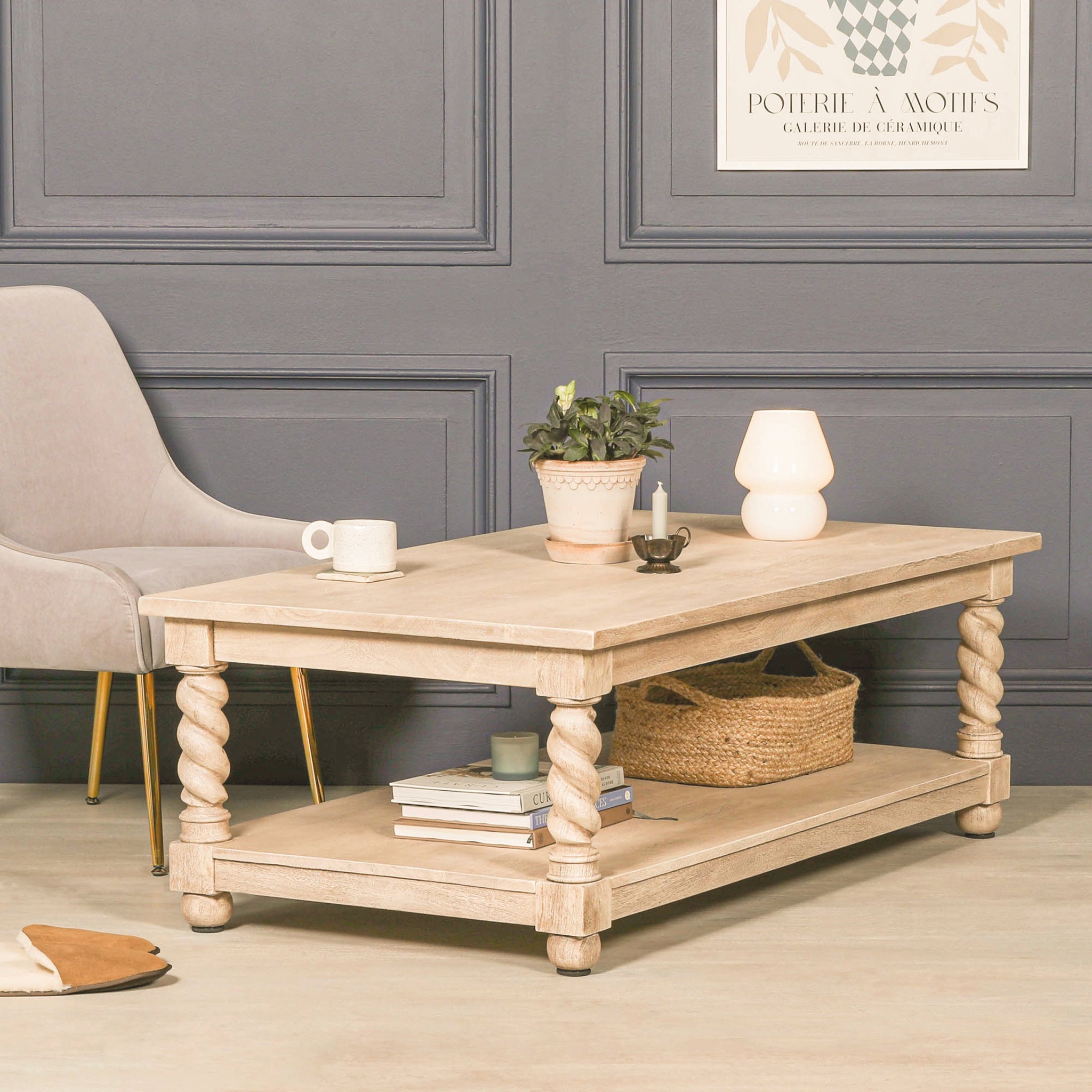 Éloi sculptural acacia wood coffee table styled in a living room, featuring a rectangular wood top, hand-carved twirl legs and spacious lower shelf for books, baskets and decorative storage.