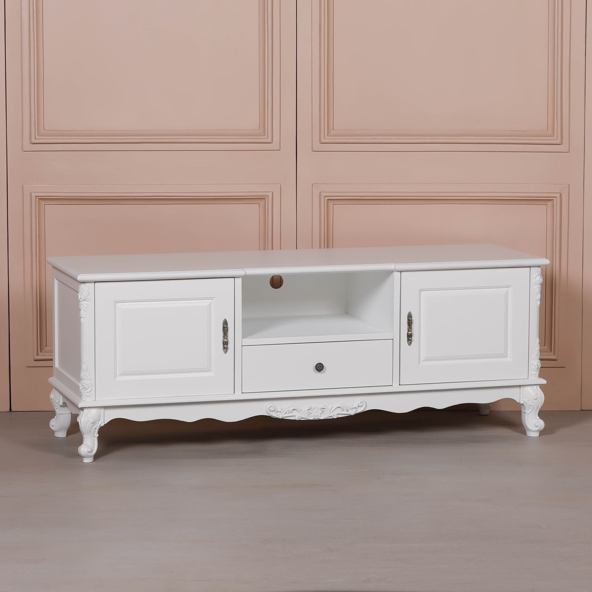 Angled view of the Éloise Large French White TV Cabinet with Hand-Carved Detailing featuring elegant white painted wood, ornate carved legs, spacious media shelving, cupboard storage and classic French country styling.