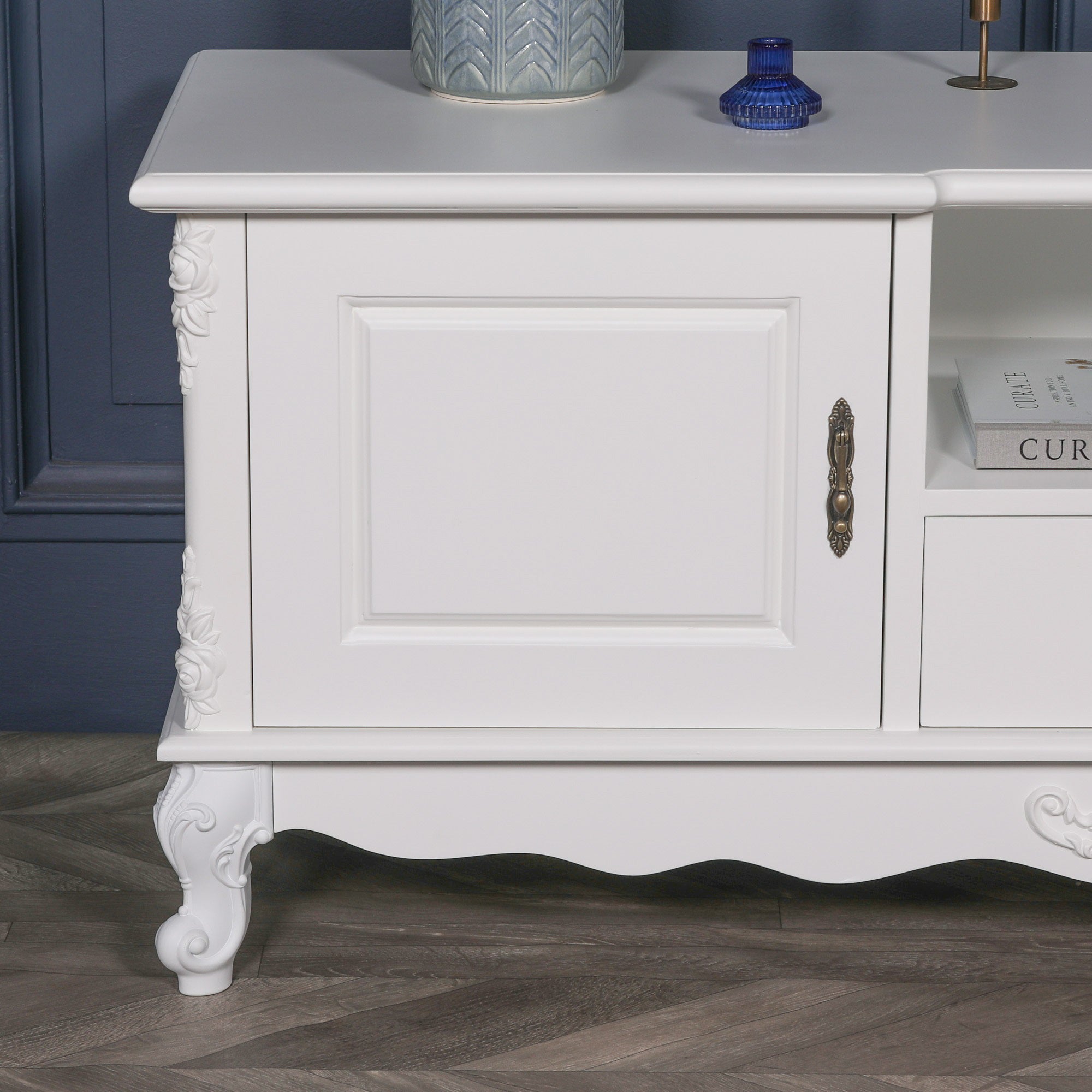 Detailed close-up of the Éloise Large French White TV Cabinet showcasing decorative brass hardware, carved floral embellishments, white painted finish and handcrafted French furniture detailing.