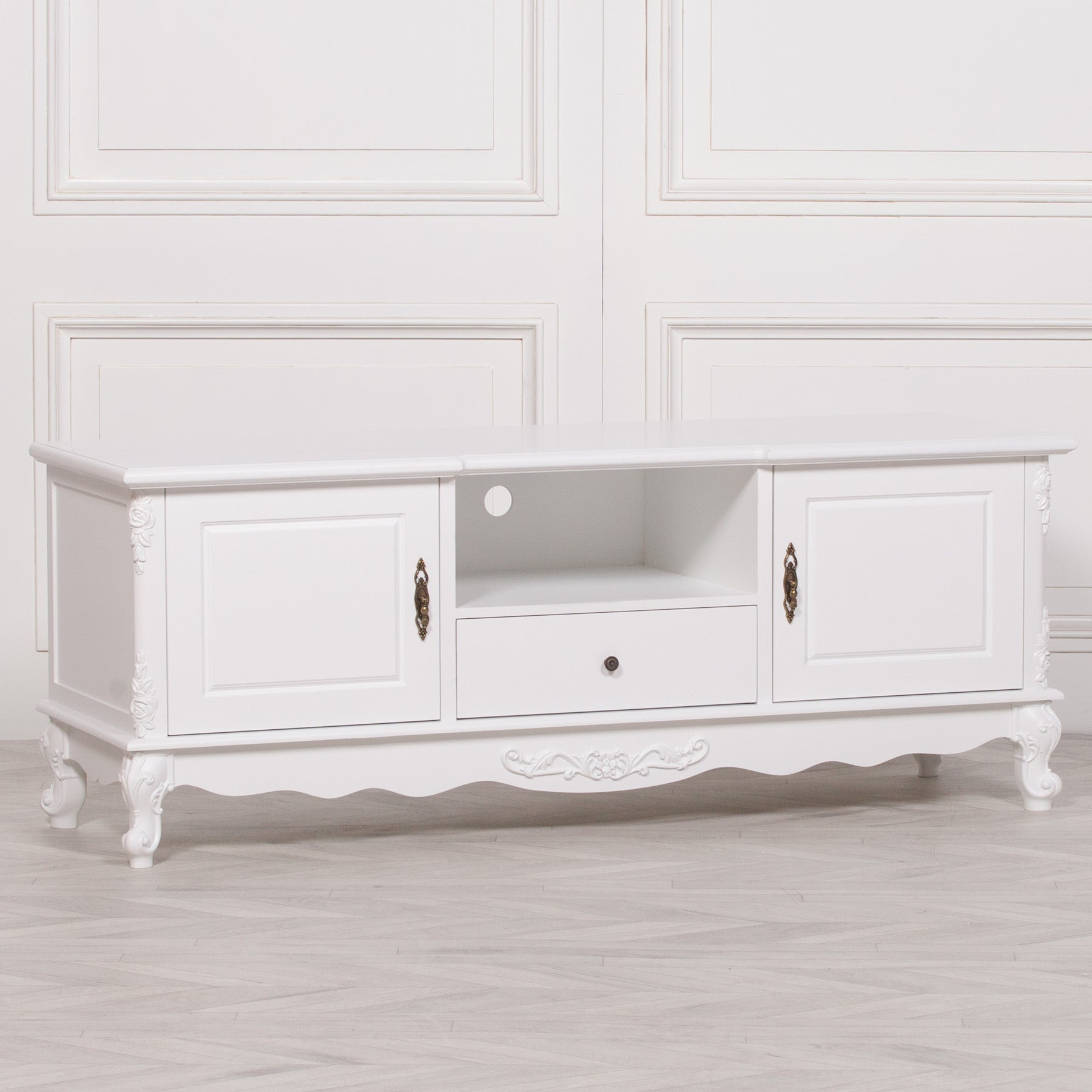 Three-quarter angle view of the Éloise Large French White TV Cabinet with Hand-Carved Detailing showcasing elegant proportions, carved legs, media shelf and spacious cupboard storage.