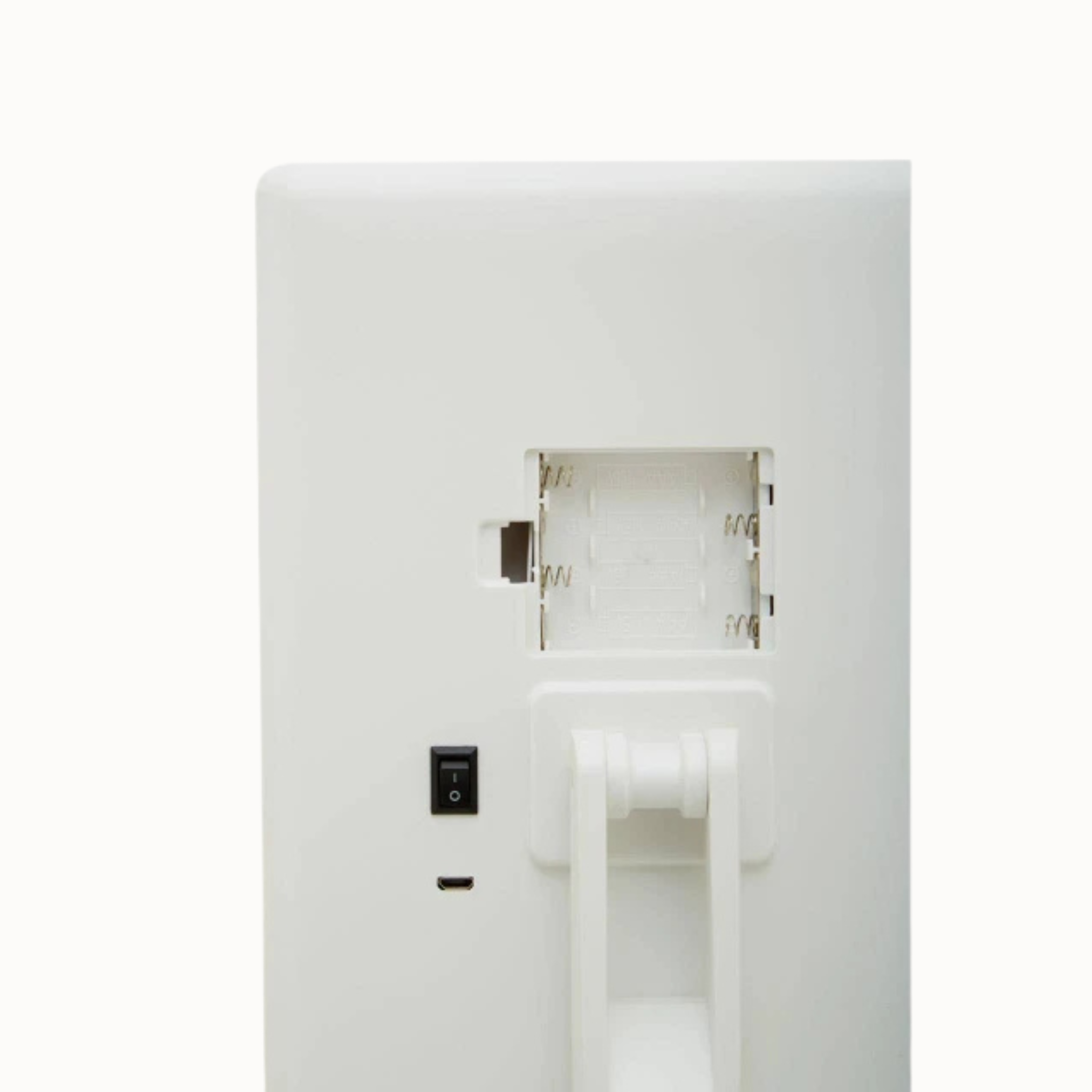 Back detail of Émile white LED vanity mirror showing battery compartment, switch and charging port on white.