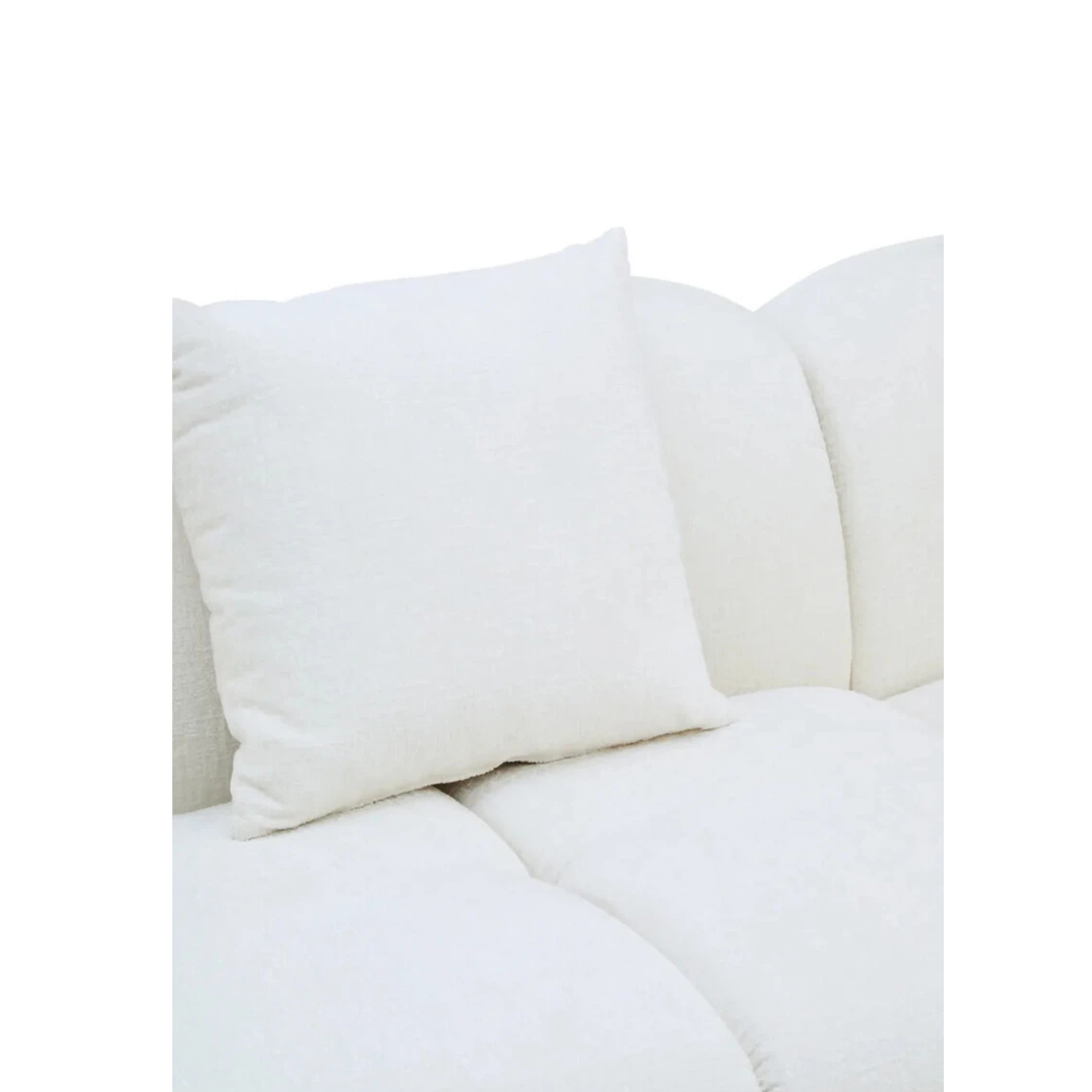 Éveline cream textured fabric sofa close-up showing soft cushion, padded seat and curved back on a white background.