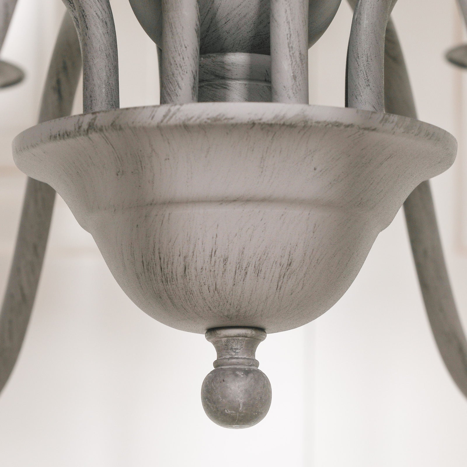 Close-up of Evrard grey chandelier central bowl and finial with distressed finish against a white background.