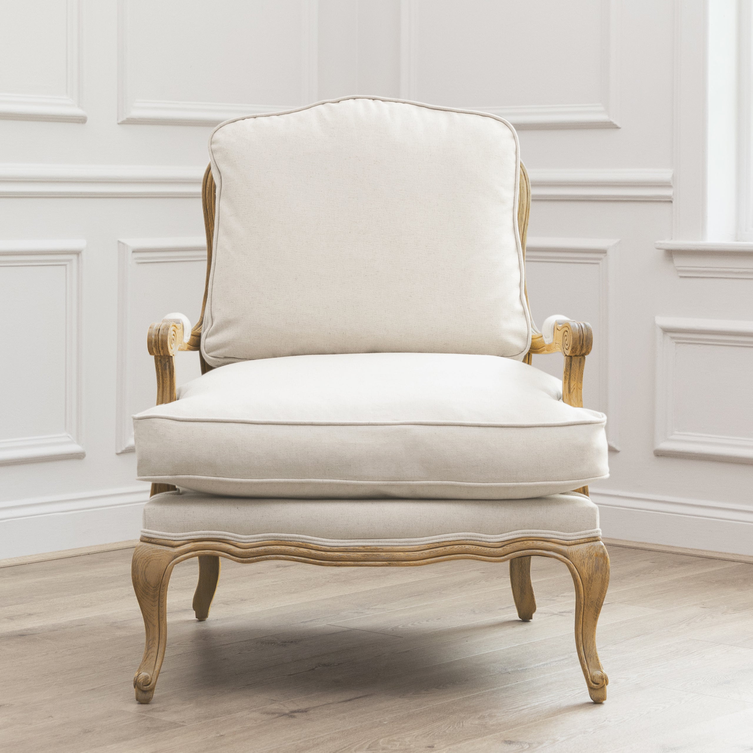 Front view of Florence cream upholstered oak accent chair against white panelled walls and light wood flooring.