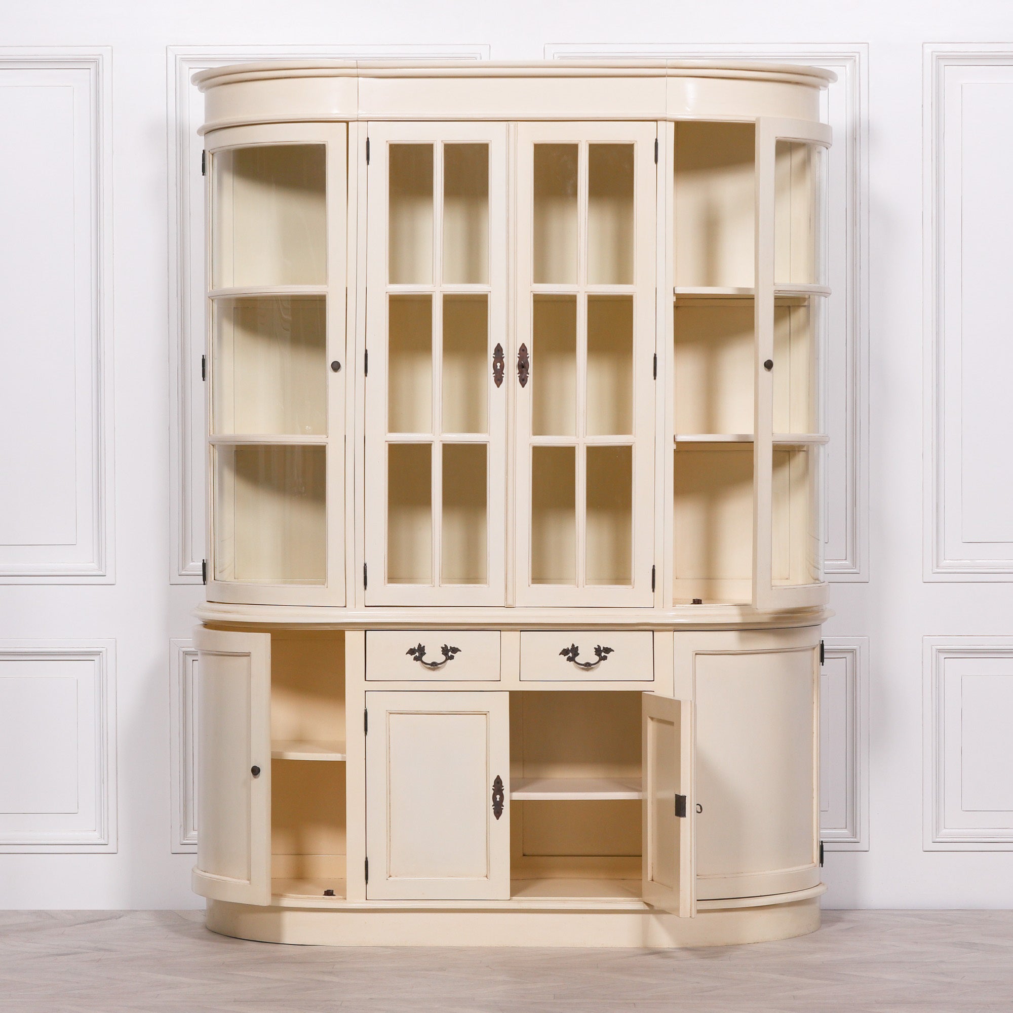 Geneviève cream mahogany display cabinet with glass doors and open storage base against a white panelled wall.