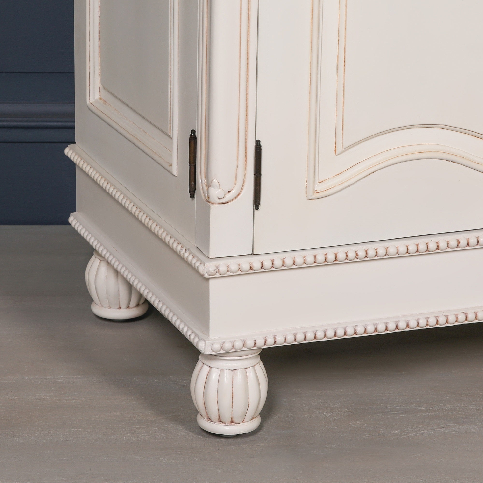 Close-up of the Geneviève Hand-Carved French Chateau Double Door Armoire Wardrobe showing the decorative beaded base, carved mahogany construction, antique finish and classic French furniture craftsmanship.