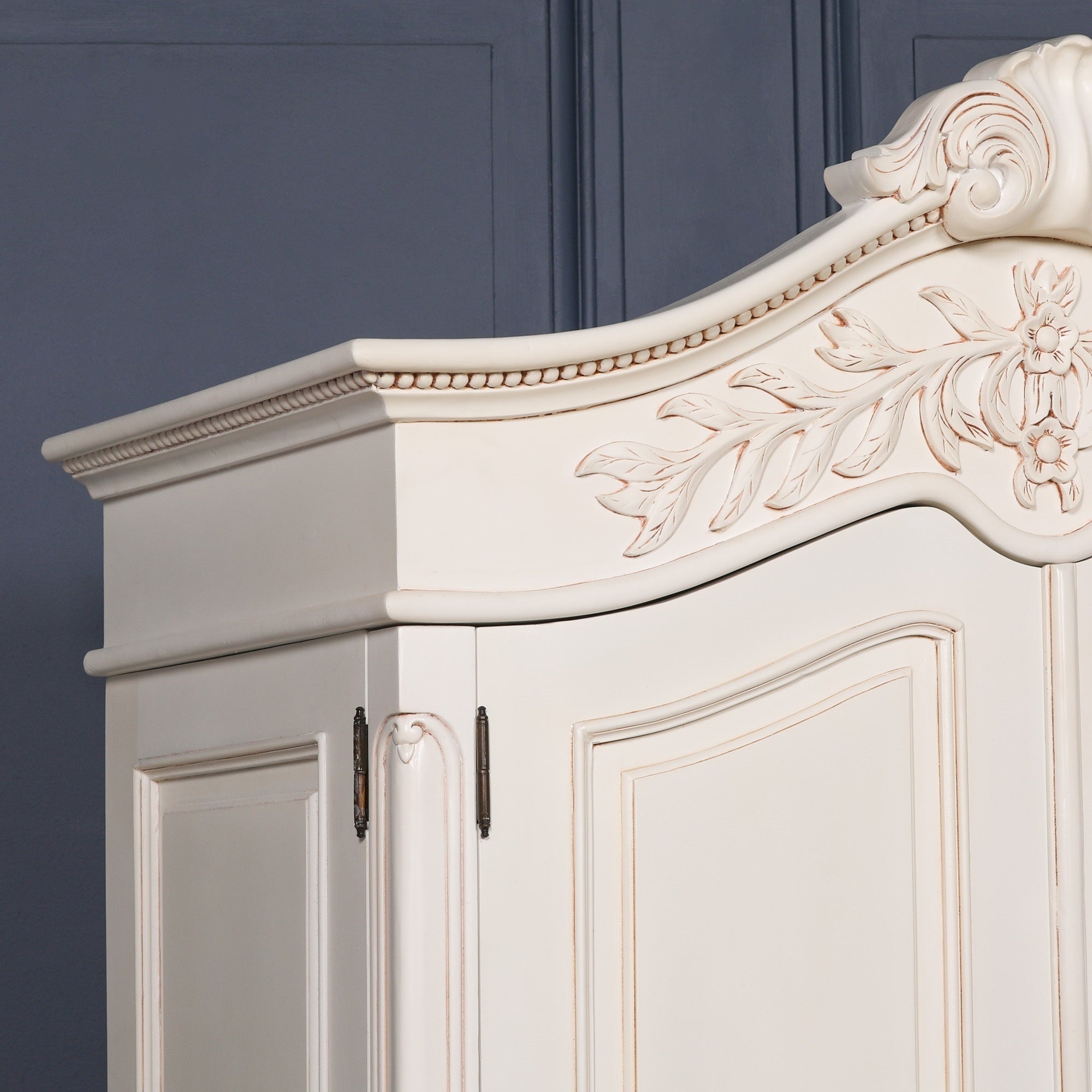Close-up of the Geneviève Hand-Carved French Chateau Double Door Armoire Wardrobe highlighting the sculpted cornice, hand-carved floral motifs, decorative beaded trim and premium White Mahogany finish.