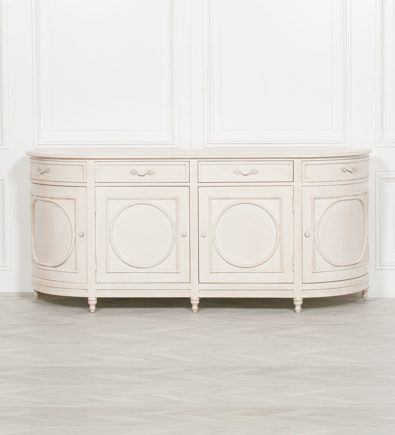 Front view of the Geneviève Large Aged Ivory Sideboard with 4 Doors, 4 Drawers & Ornate Detailing featuring four cabinet doors, four drawers, decorative moulding, curved breakfront profile and timeless French-inspired design.