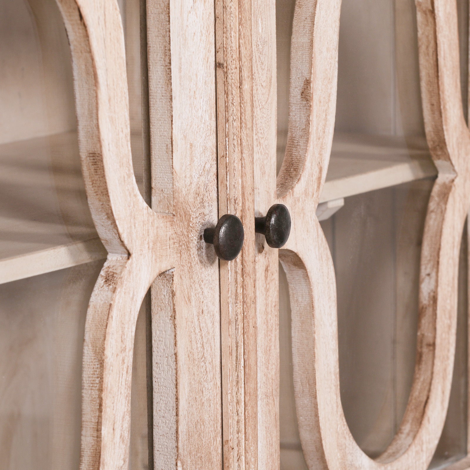 Close-up of the Henri Rustic Mango Wood Display Cabinet showcasing the decorative ornate glazed doors, handcrafted wooden framework, black metal door knobs and beautifully textured weathered mango wood finish.