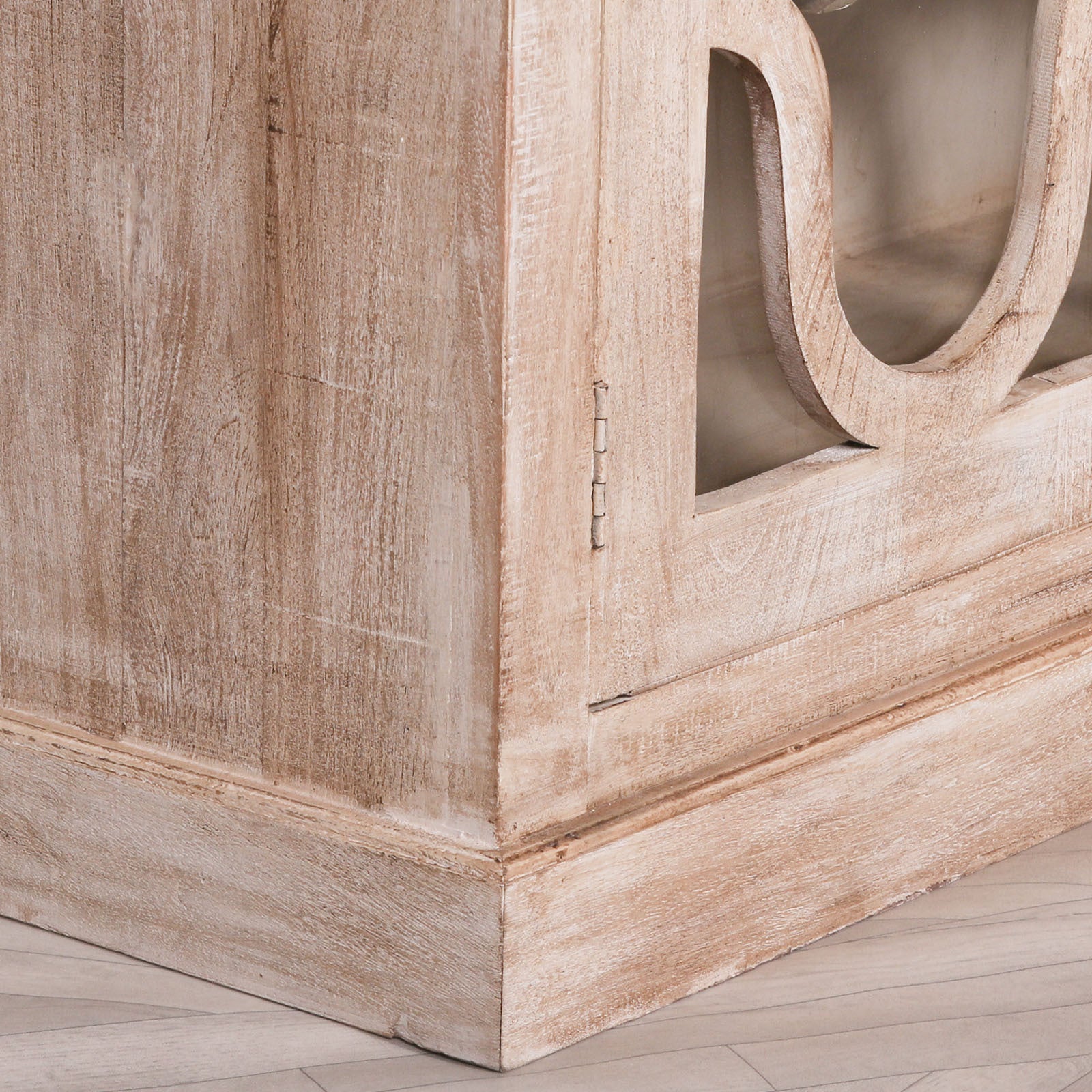 Detailed side view of the Henri Rustic Mango Wood Display Cabinet featuring the handcrafted side panel, moulded plinth base, natural mango wood grain and elegant weathered rustic finish.