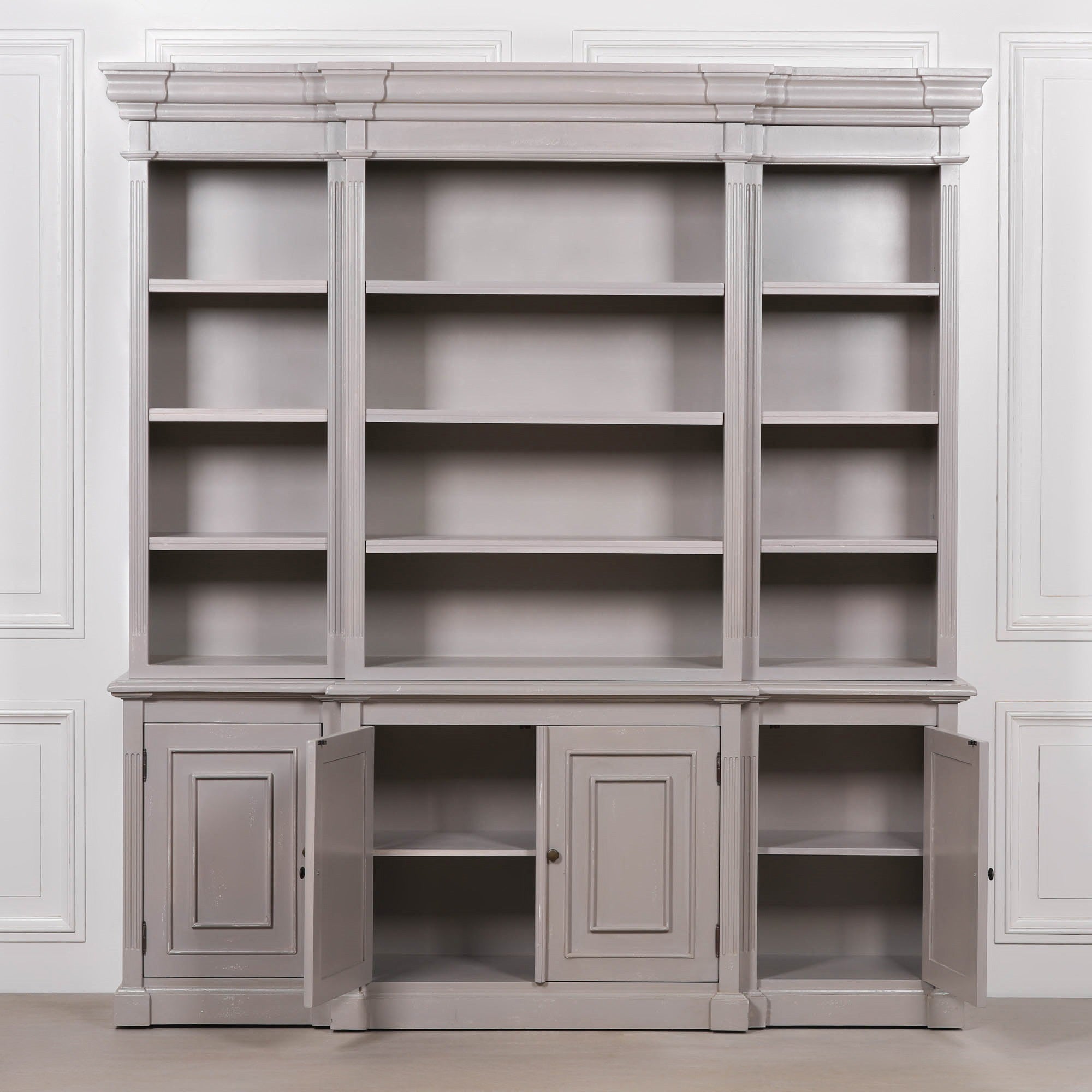 Laurent 200cm distressed mahogany bookcase with adjustable shelves and open 4 door storage against a white panelled wall