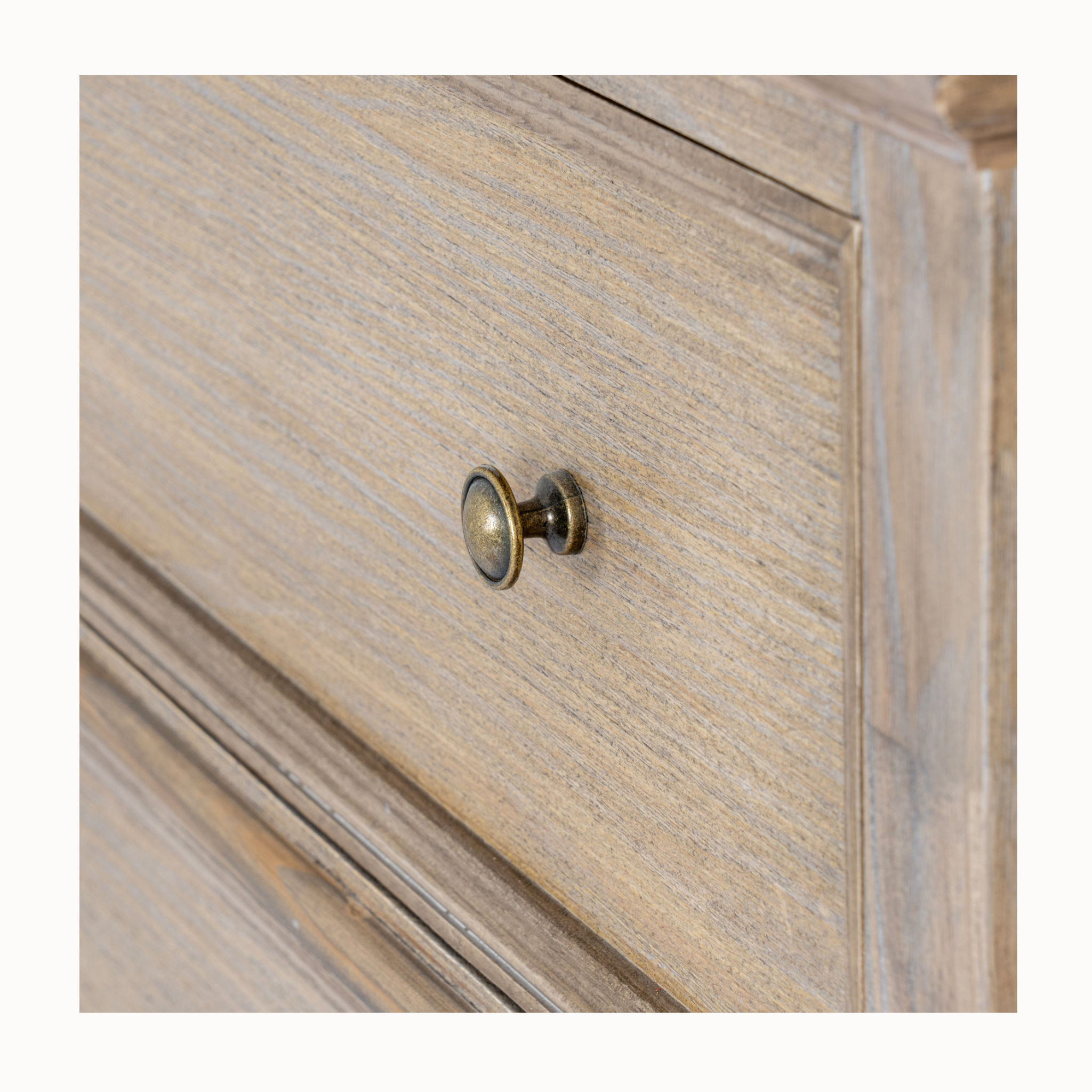 Close-up of Laurent brown wood chest showing weathered wood grain and antique brass drawer knob on white.