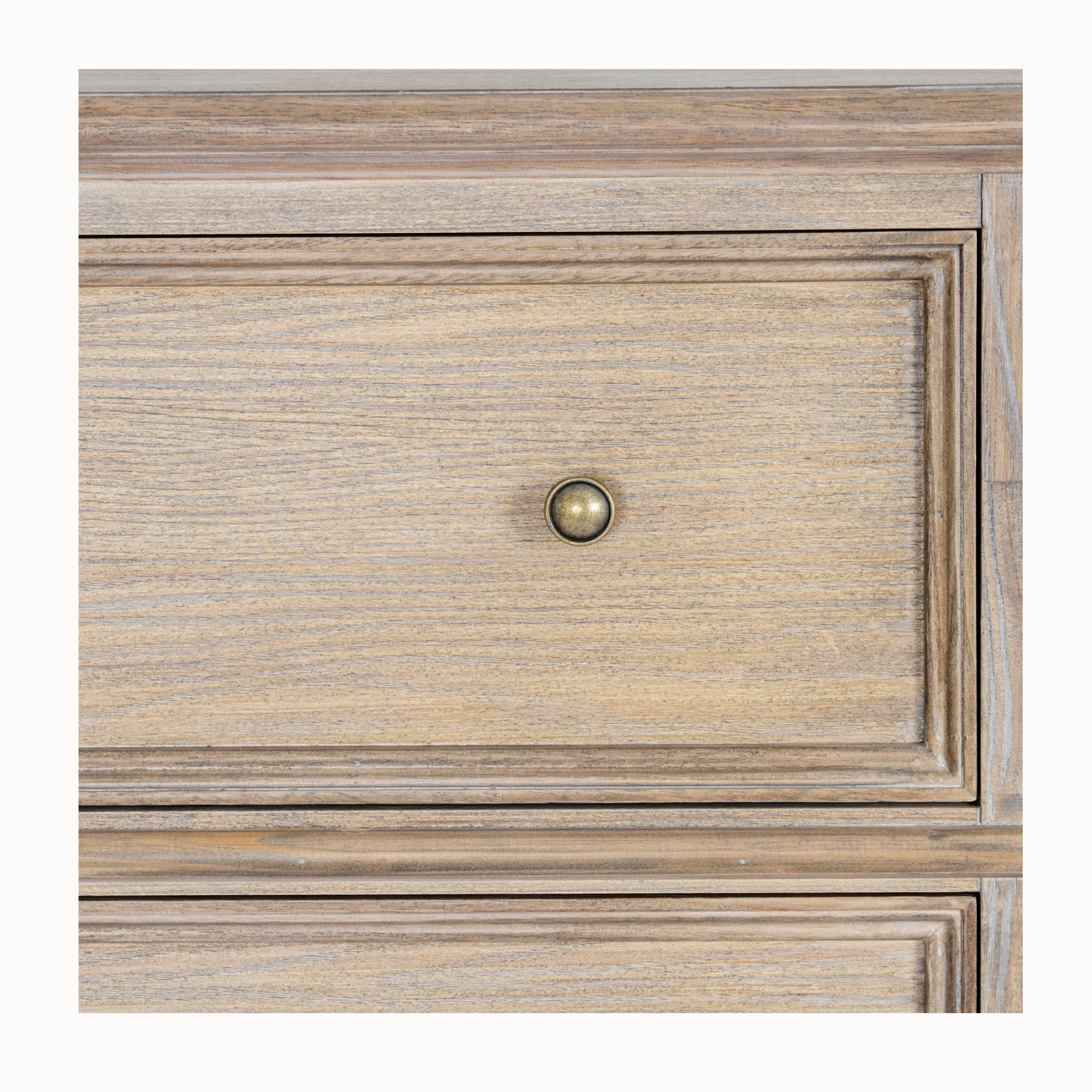 Close-up of Laurent brown wood chest drawer showing panelled front, wood grain and brass knob on white.