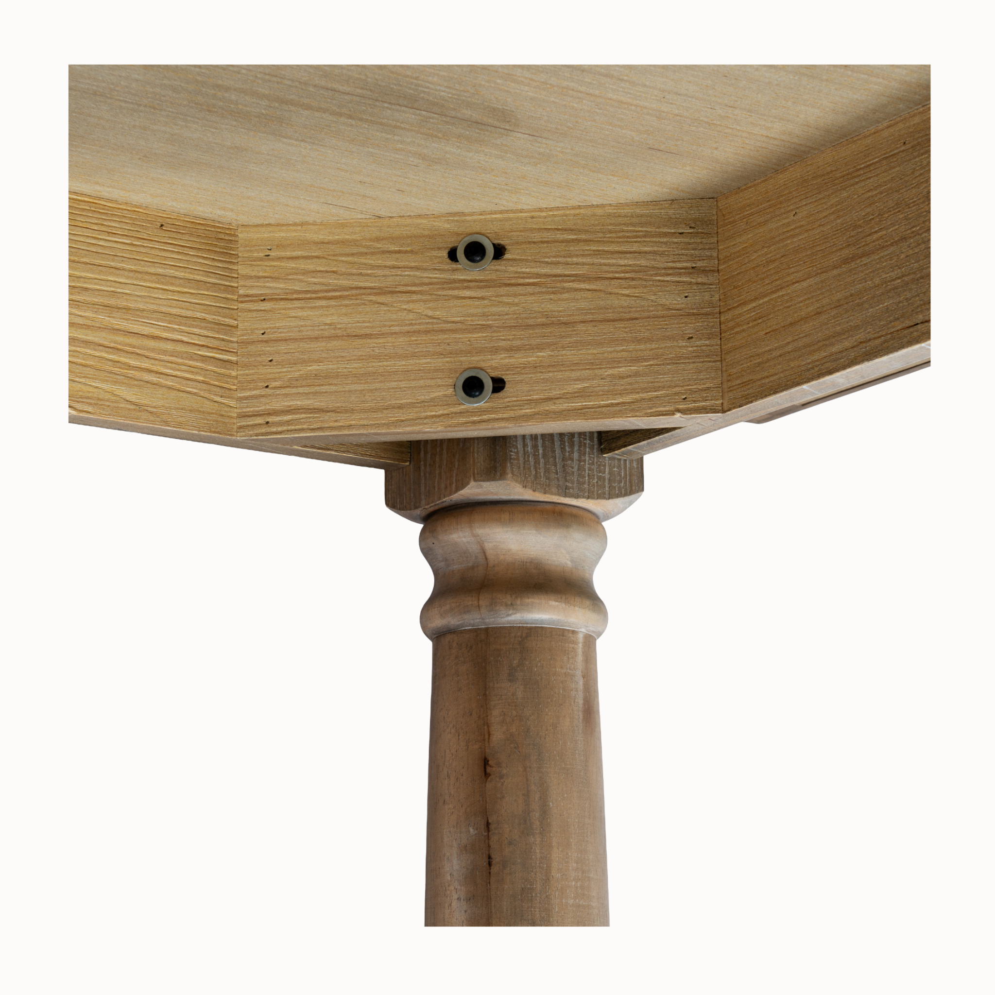 Close-up of Laurent brown wood dining table apron and turned leg construction detail against a white background.