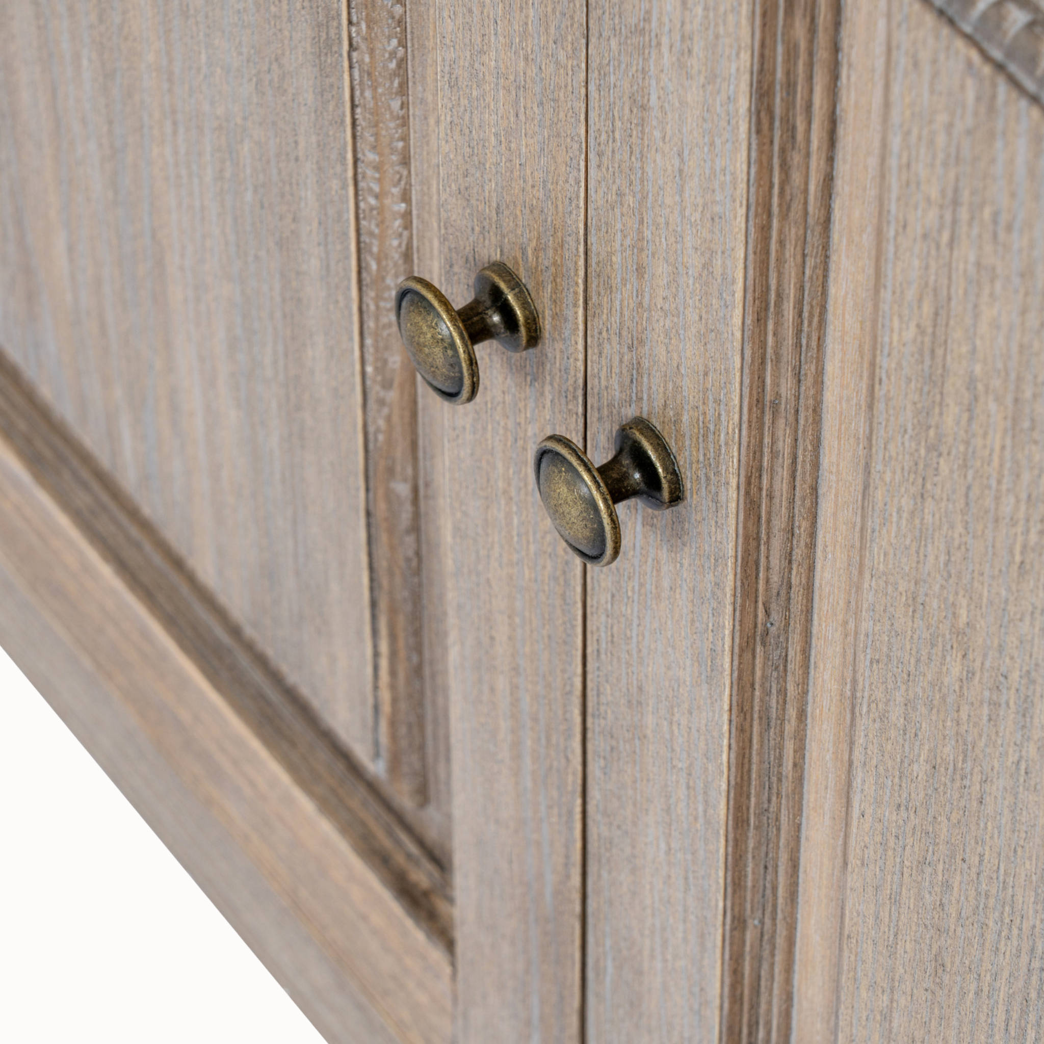 Close-up of Laurent brown wood display cabinet showing antique brass door knobs and wood grain on a white background.