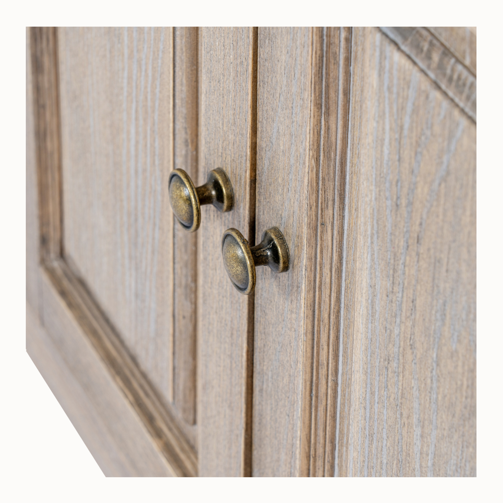 Close-up of Laurent brown wood sideboard showing antique brass knobs, panelled doors and wood grain on a white background.