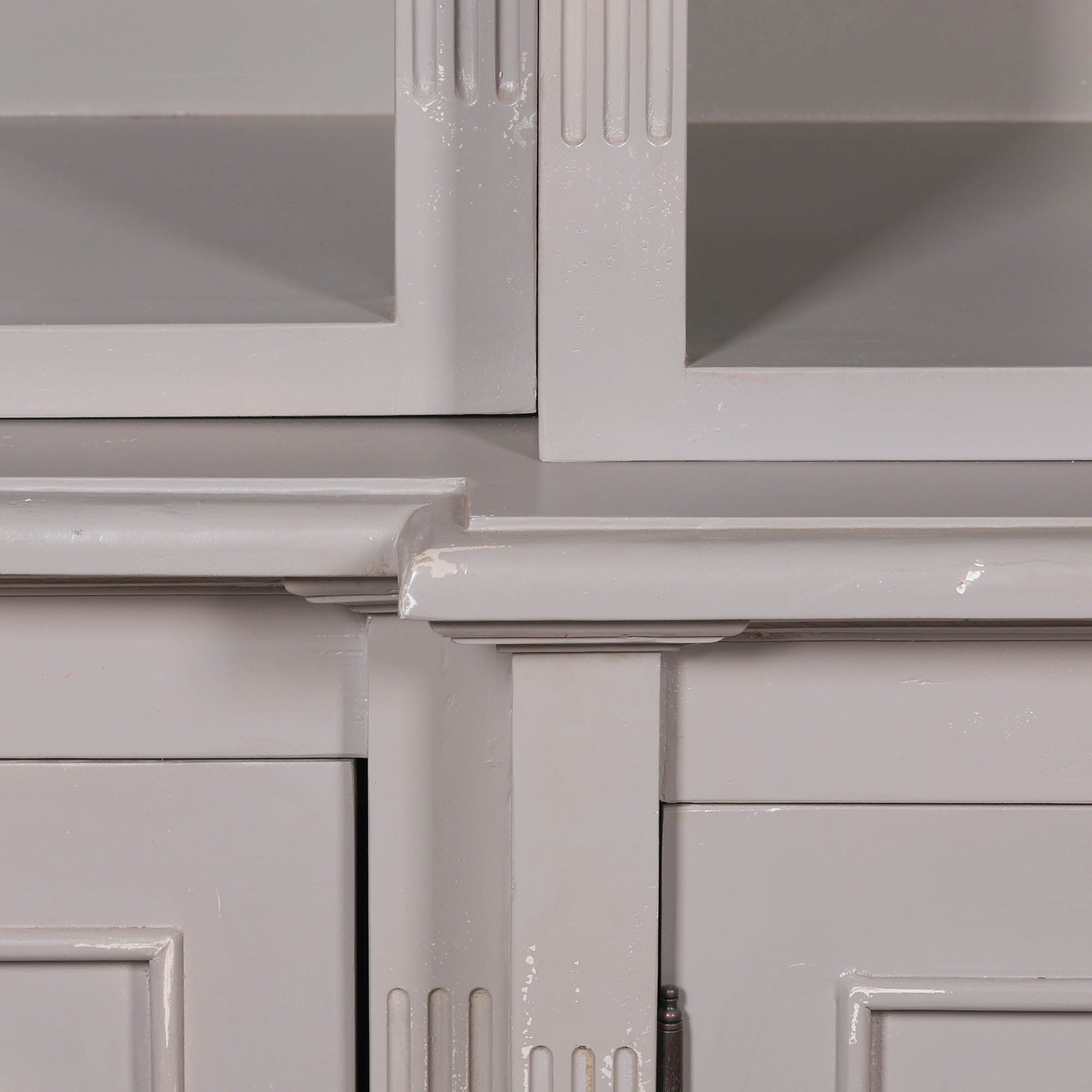 Close-up of Laurent mahogany bookcase showing distressed painted finish and shelf moulding against a white background