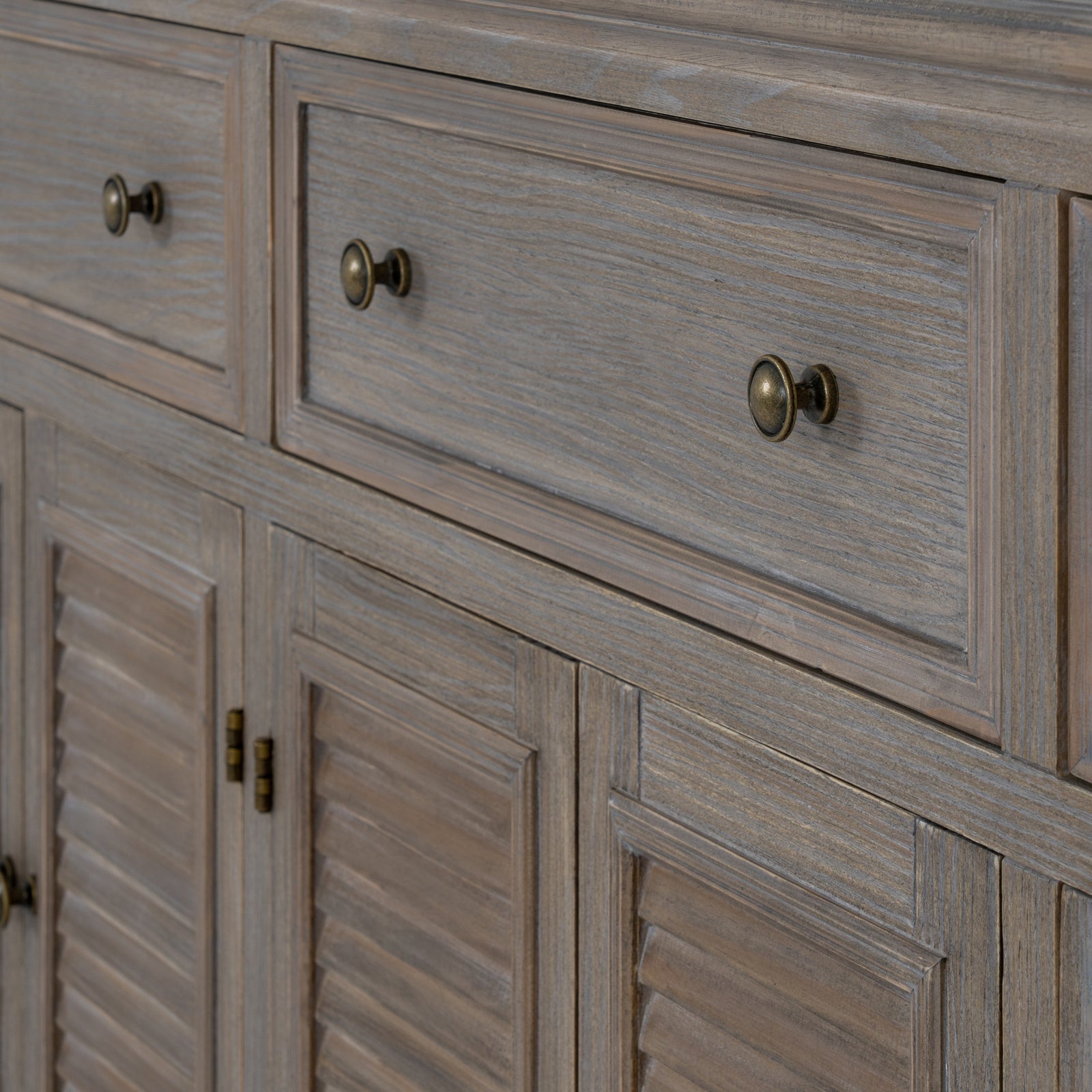 Close-up of the Laurent Large Wood Display Cabinet Set highlighting solid wood drawer fronts, antique brass-effect knobs, louvred cupboard doors and beautifully textured natural wood grain.