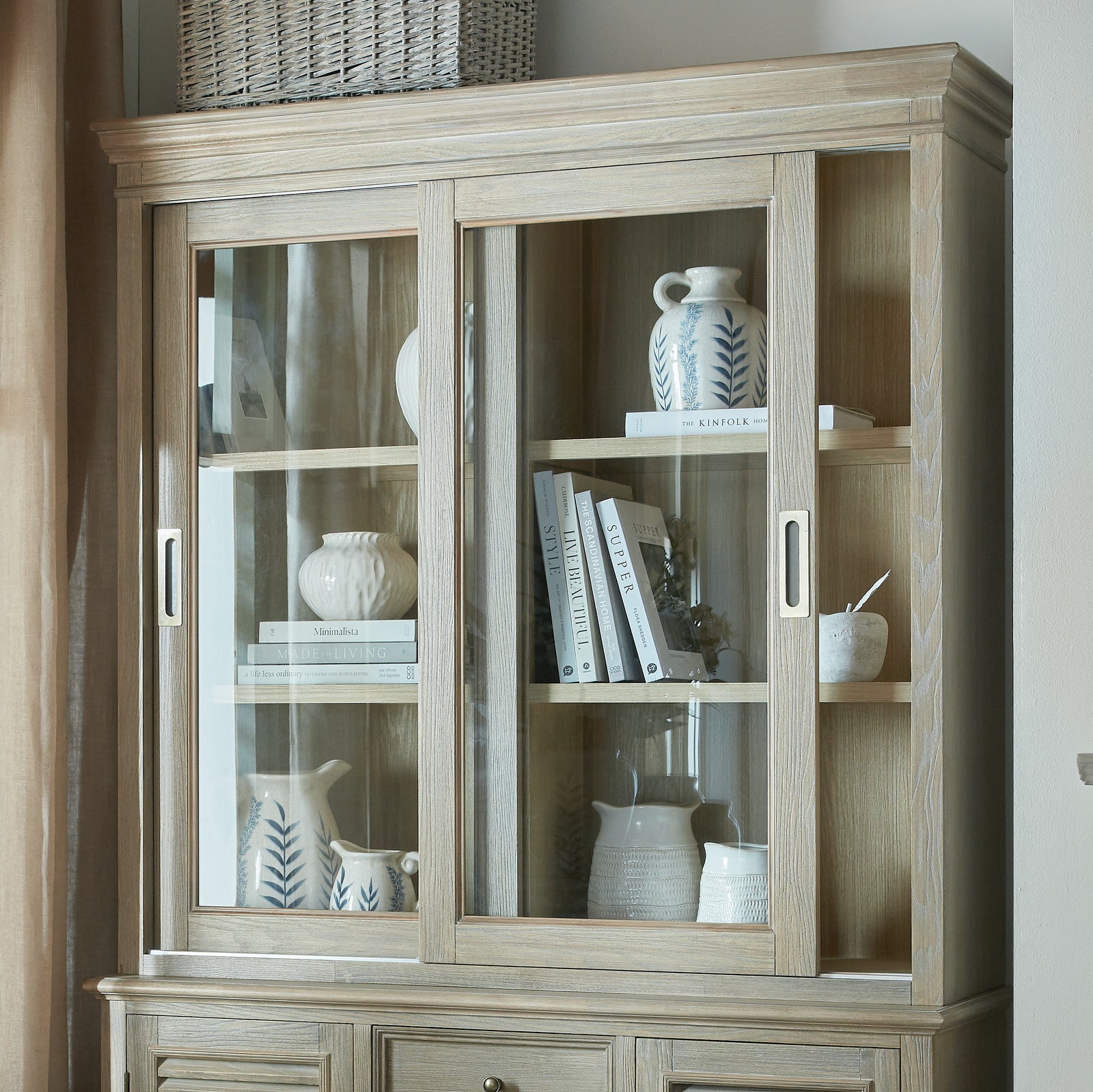 Close-up of the Laurent Sliding Glass Dresser Cabinet Top styled with ceramic vases, books and decorative accessories, showcasing sliding glass doors, open display shelving and natural wood craftsmanship for elegant living room storage.