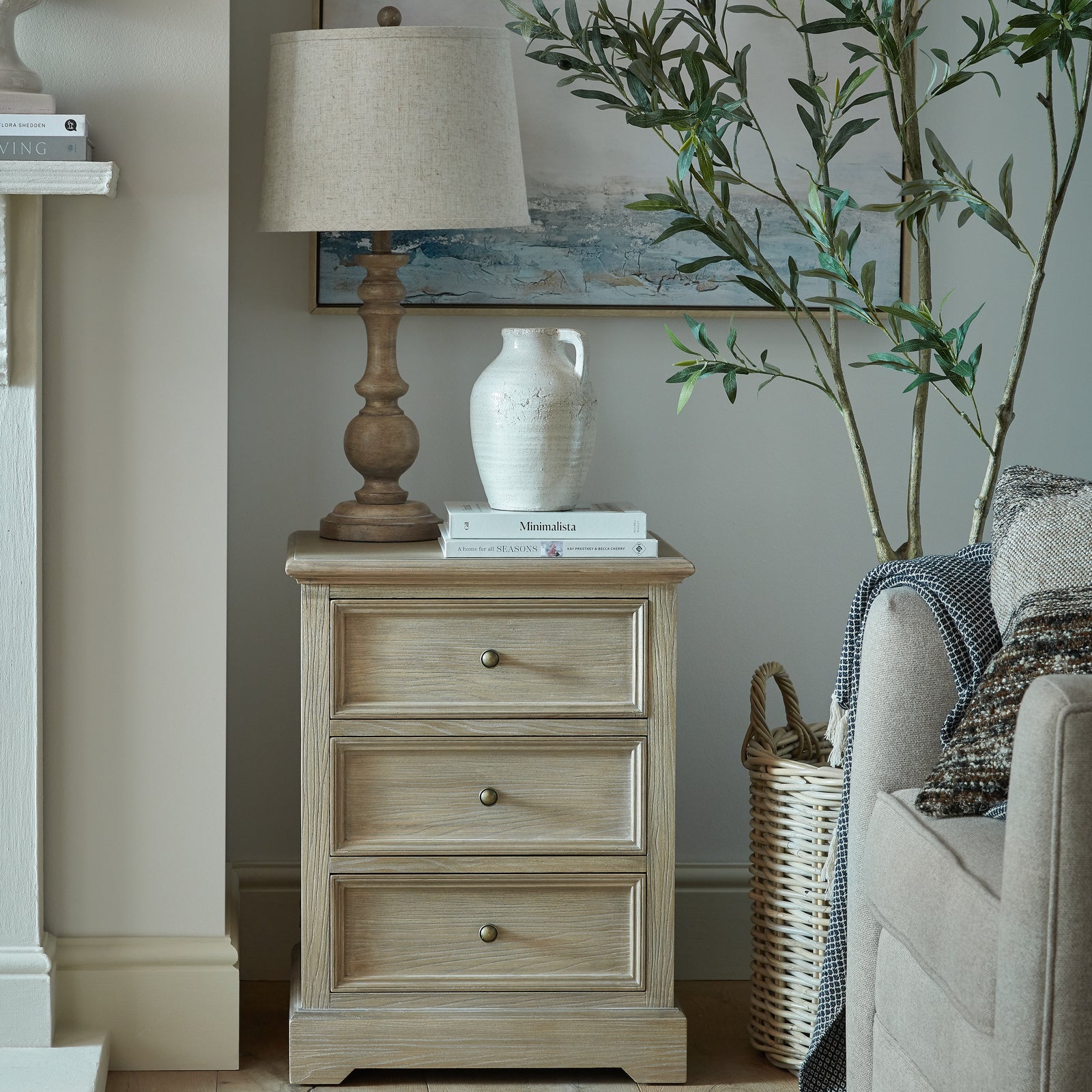 Laurent Wood Chest of Drawers with 3 Drawers styled in a contemporary living room beside a sofa, featuring a natural wood finish, three spacious storage drawers, antique brass knobs and timeless rustic design for stylish home organisation.