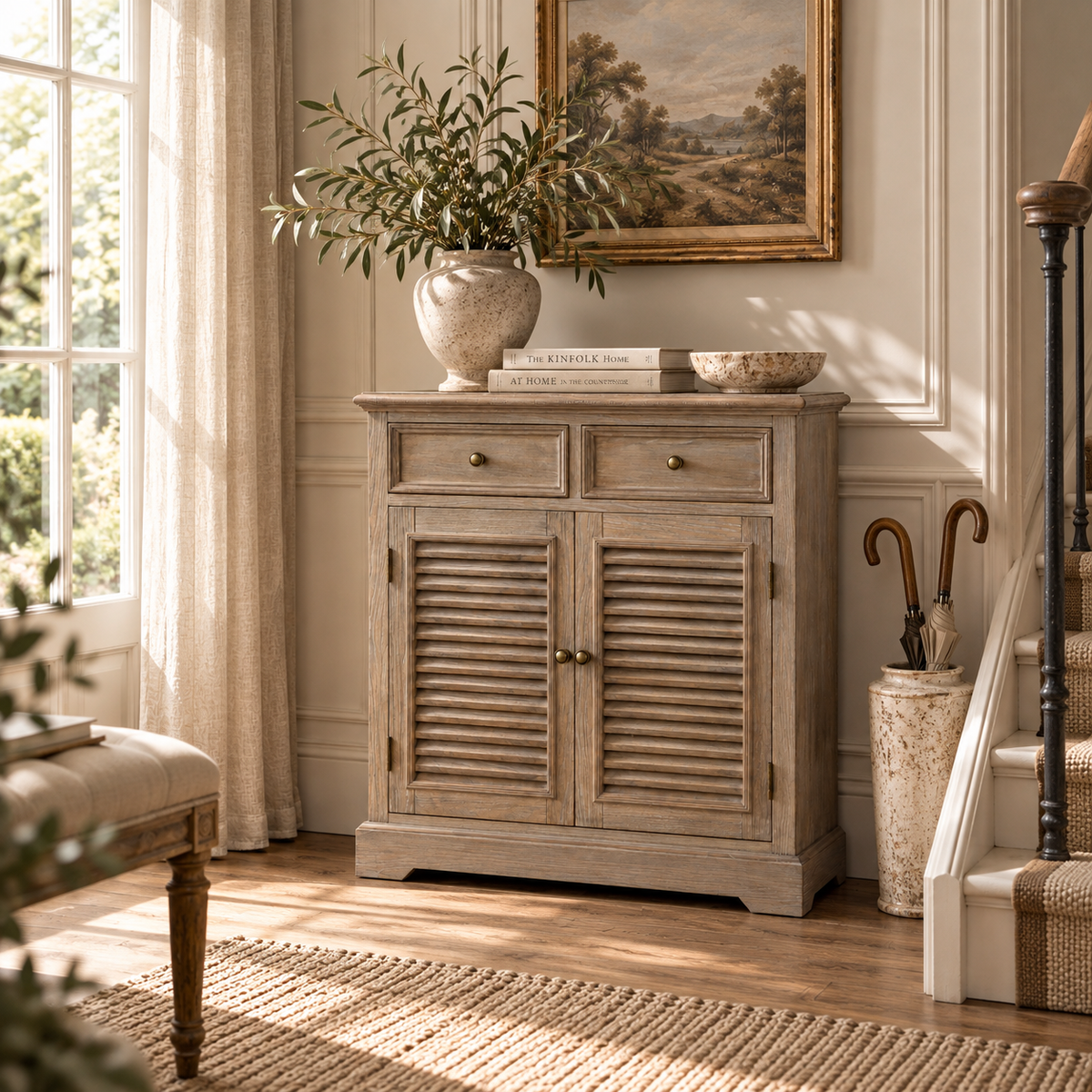 Laurent wood storage cabinet with 2 drawers and louvred doors beside a staircase in a bright sunlit hallway