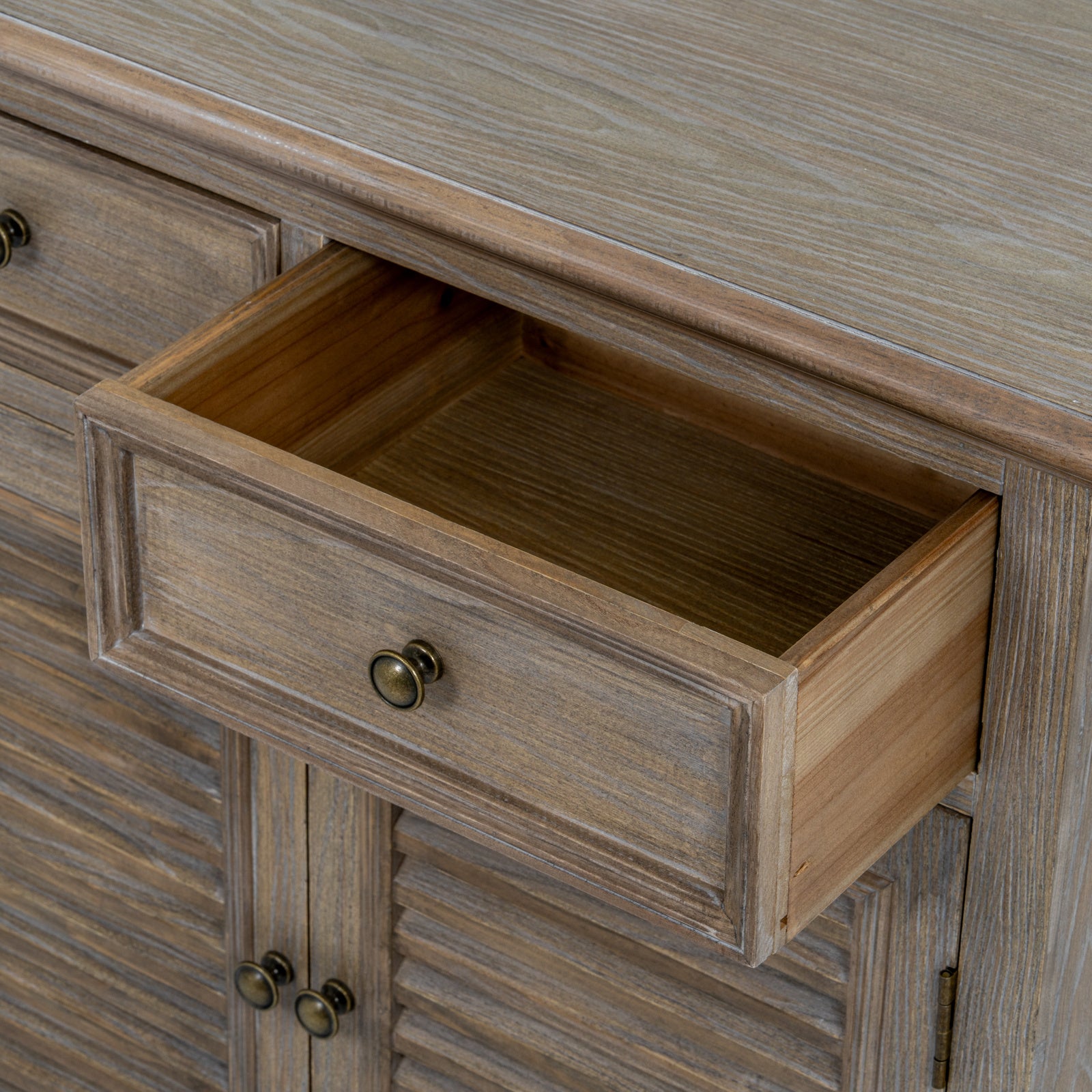 Close-up of the Laurent Wood Storage Chest with 2 Doors & 2 Drawers featuring the fully extended storage drawer, spacious interior, natural wood grain and antique brass knob, showcasing practical everyday storage.